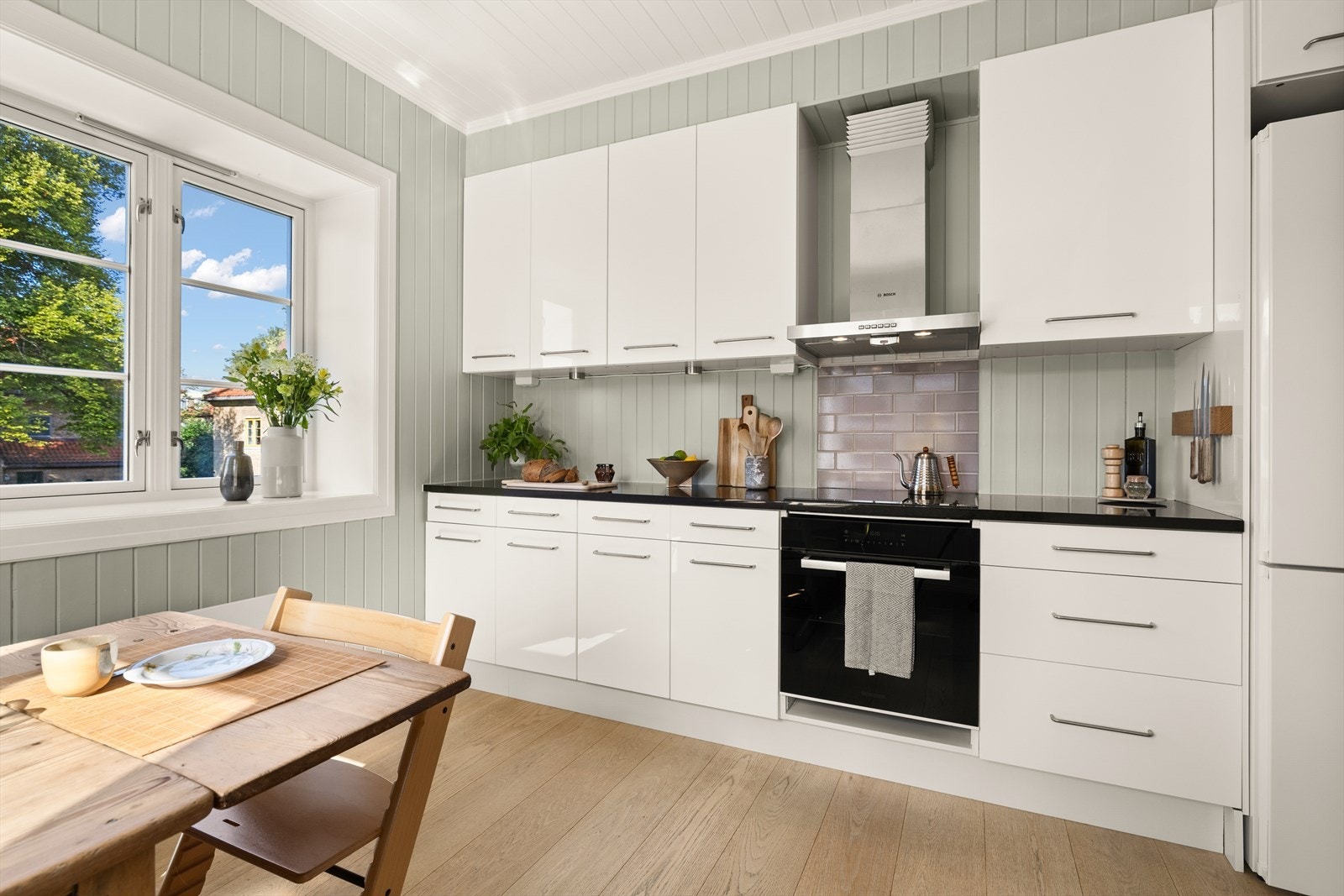 Kjøkkeninnredning fra Ikea med hvite, høyglansede fronter og takhøye skrog. Galleribilde