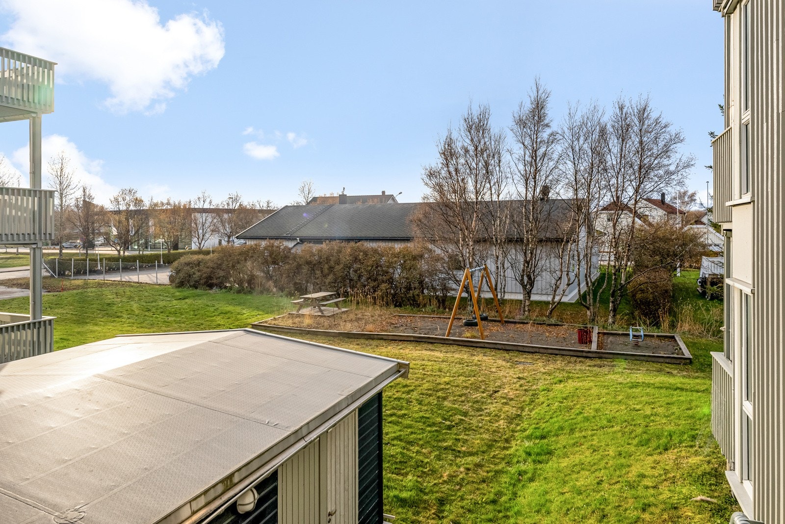 Balkongen har utsyn over felles hageareal, mot trivelig trehusbebyggelse i front. Galleribilde
