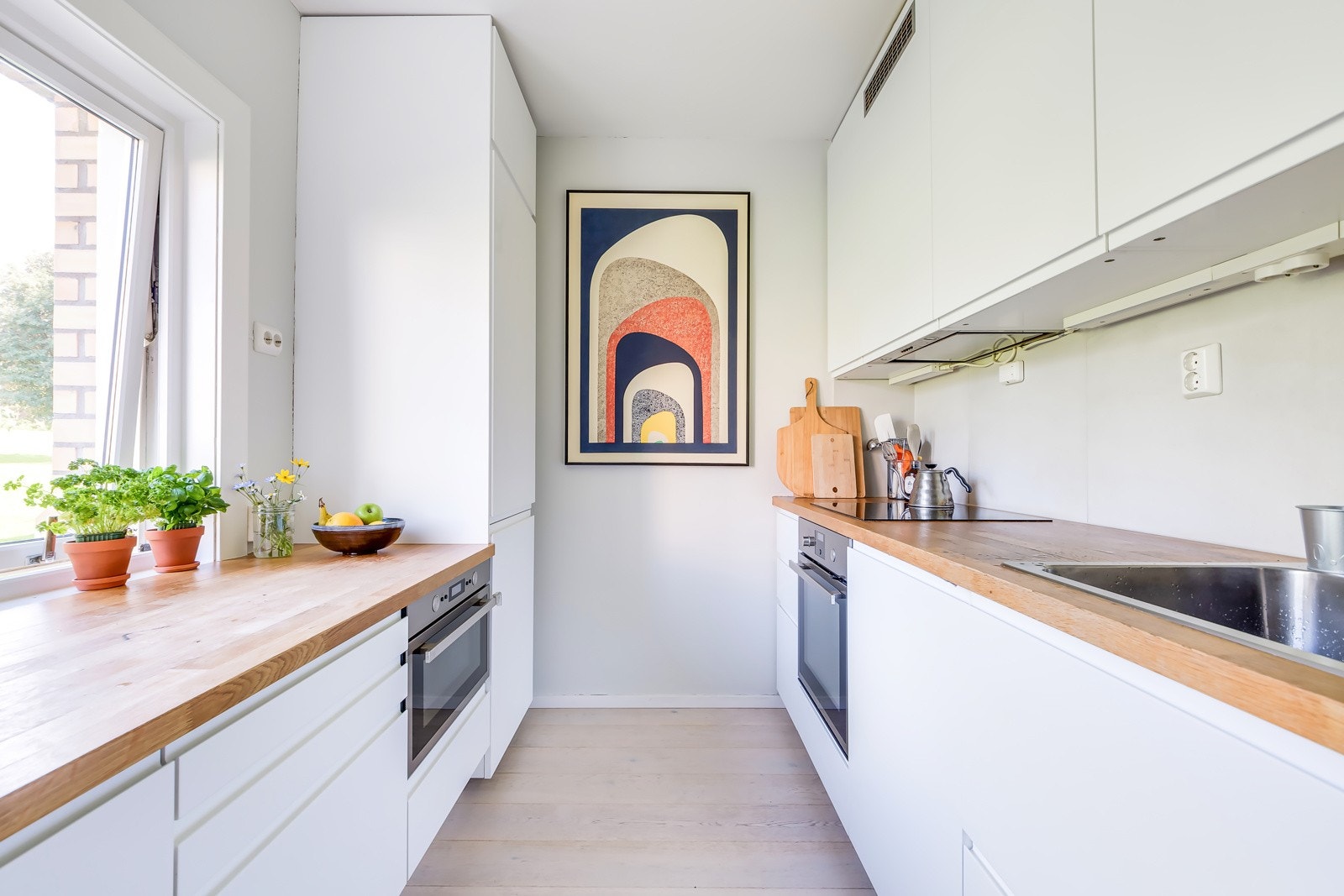 Kjøkkenet ble pusset opp i 2017. Innredningen har slette fronter i hvit-utførelse og benkeplate av tre. Galleribilde