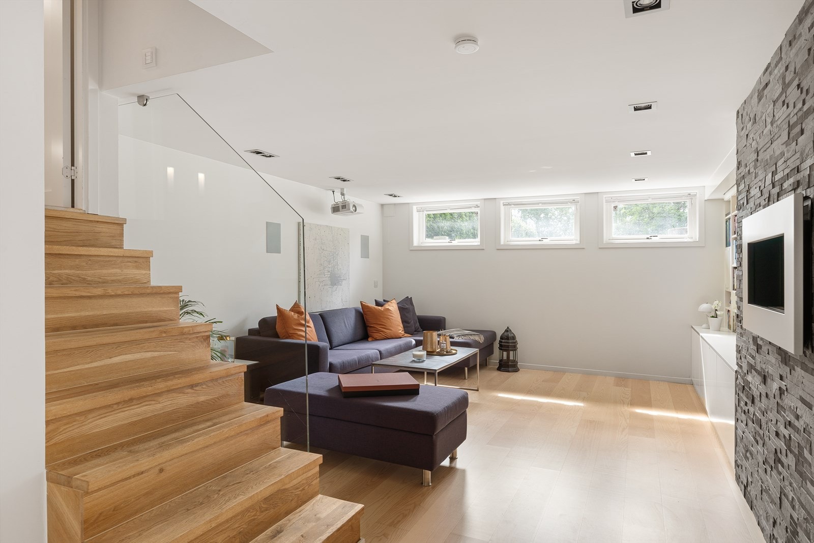 Hyggelig TV-stue med god plass til å møblere med sofagruppe og tv-benk med tilhørende møblement. Bioetanolpeis på veggen skaper en lun atmosfære Galleribilde