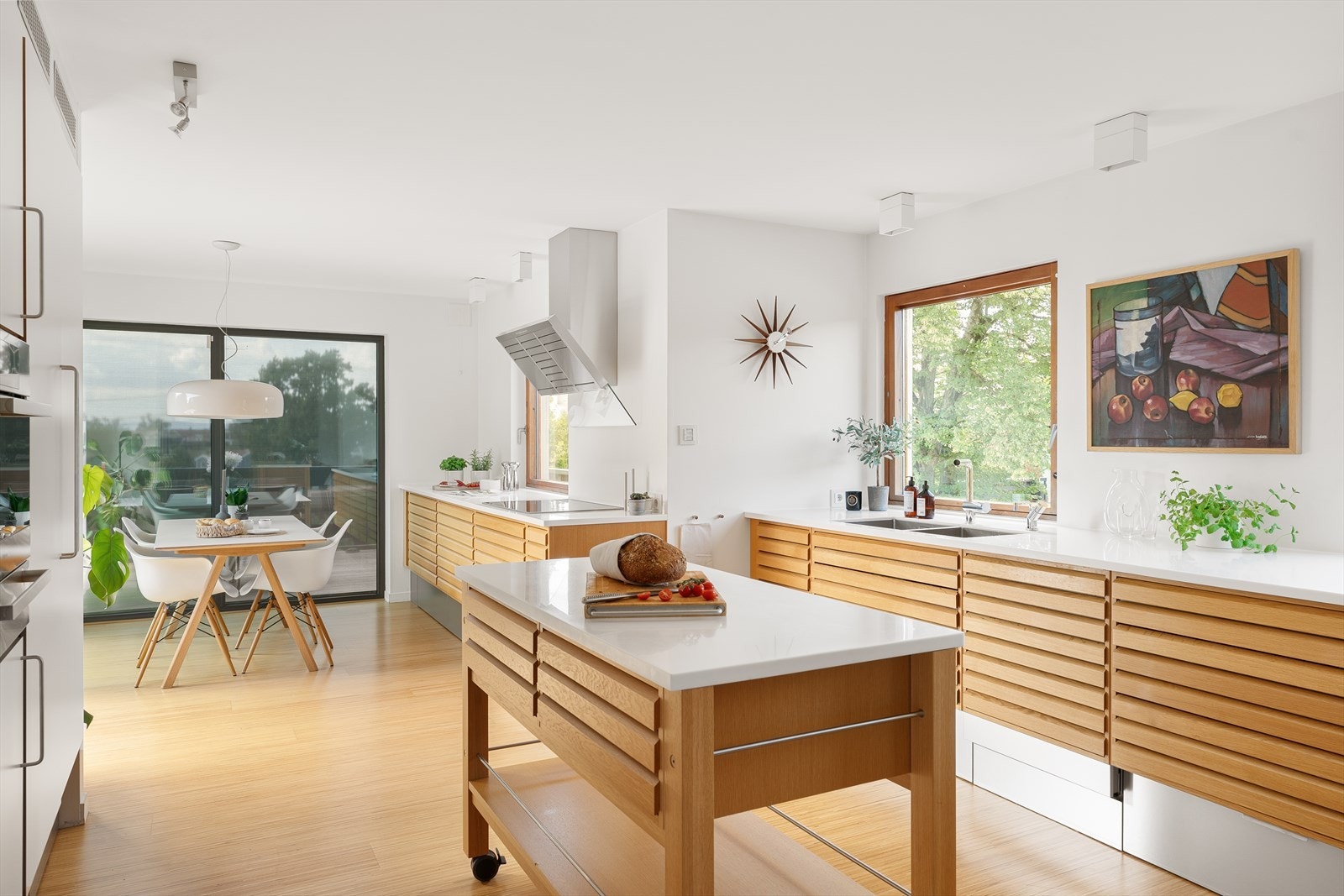 Innredning i massive eikestaver og glatte fornter med sokkelskuff. Benkeplate i corian med underlimte kummer i rustfritt stål med ett-greps blandebatteri og quooker med kokende vann rett fra springen. Galleribilde