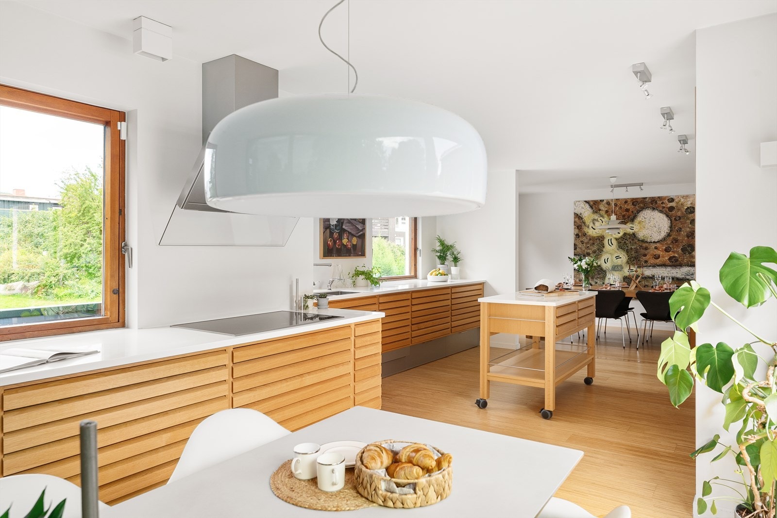 Lyse, åpne flater og naturlige materialer skaper en innbydende atmosfære og gjør dette kjøkkenet til et perfekt samlingspunkt for familie og venner. Galleribilde