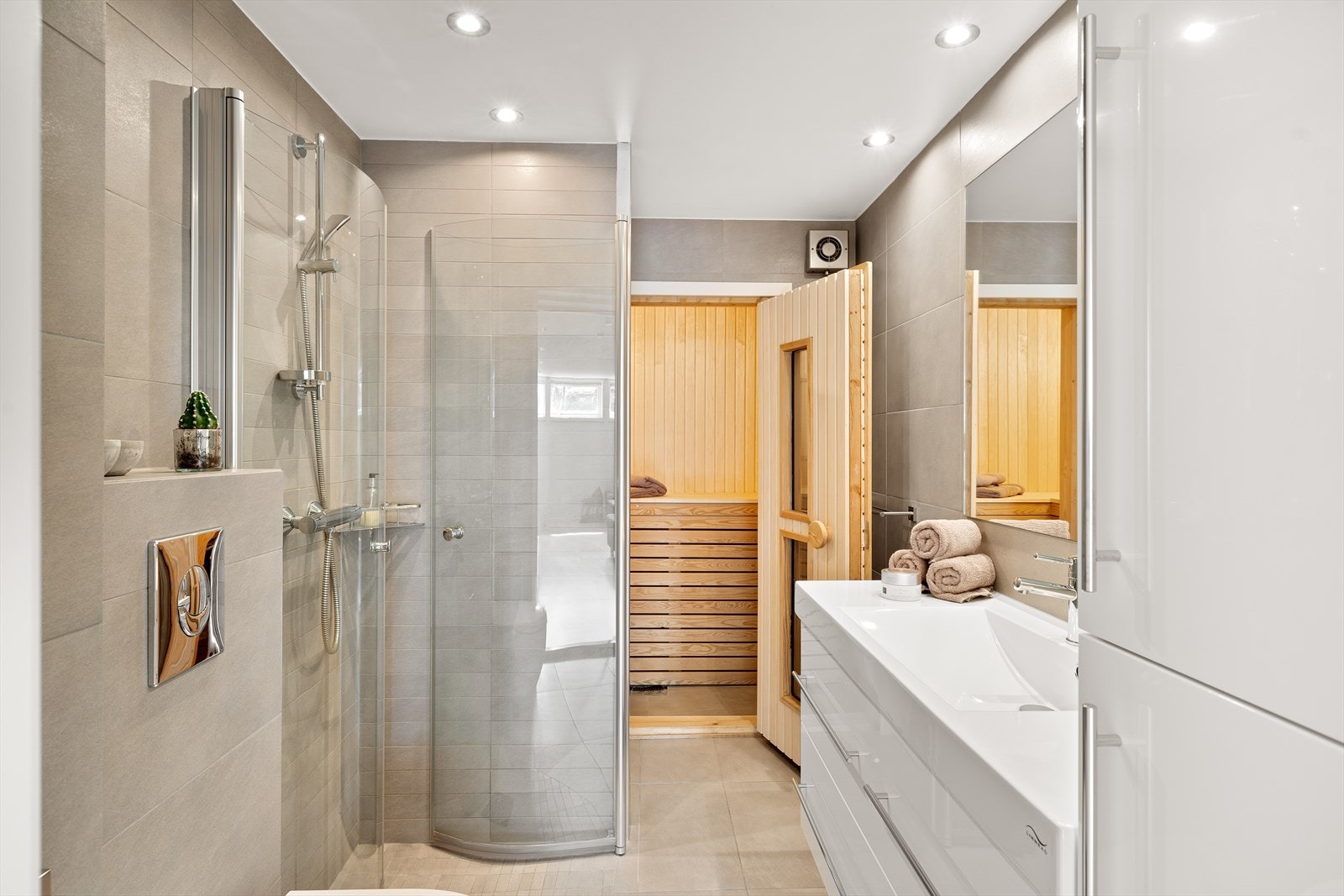 Lekkert og moderne bad fra 2011 med badstu og innfelte downlights i himling. Badet har flislagt gulv med varmekabler, flislagte vegger og malte gipsplater i taket. Badet er innredet med servant, dusjdører i herdet glass og vegghengt toalett. Galleribilde