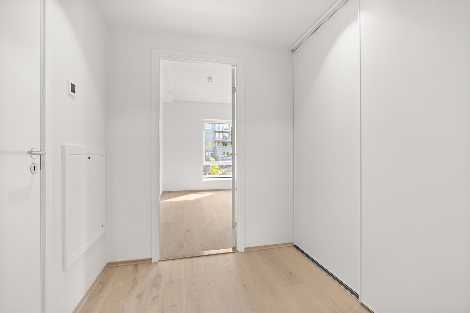 Entré/gang med 1-stavs parkett med vannbåren gulvvarme og skyvedørsgarderobe Galleribilde