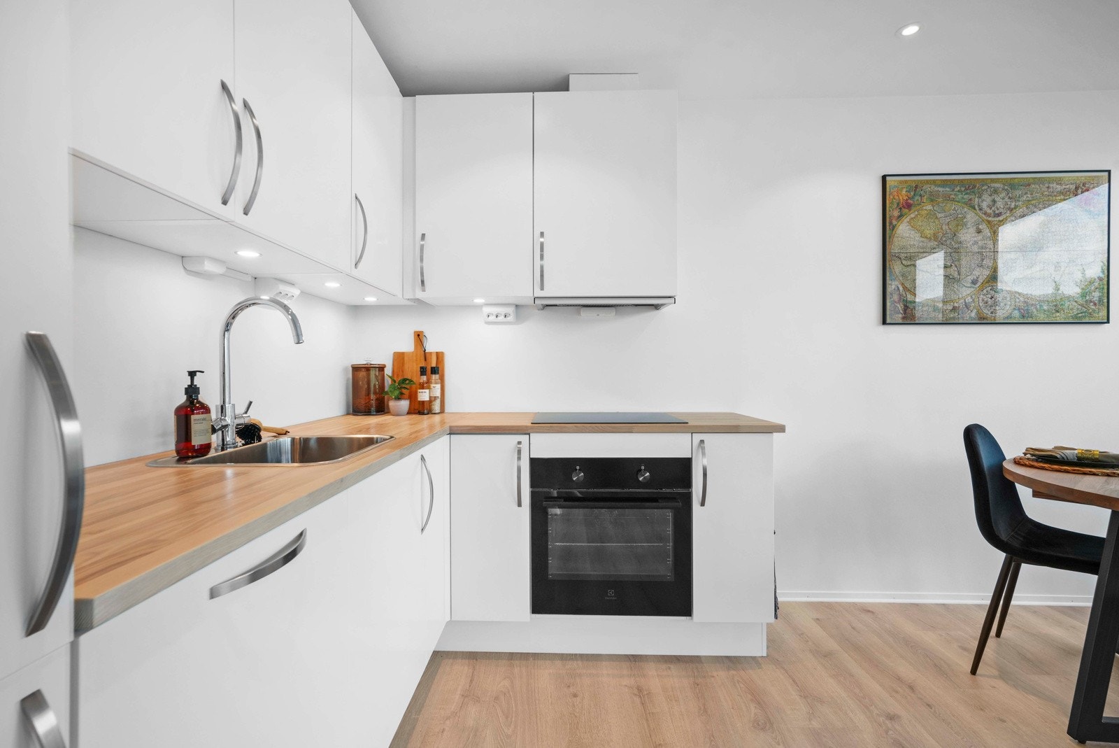 Kjøkkeninnredning fra HTH med lysmalte fronter, heltre benkeplate og integrerte hvitevarer Galleribilde