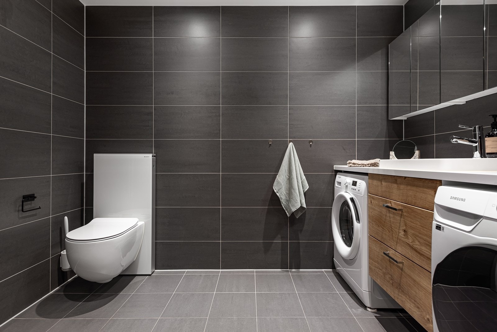 Leilighetens største bad har pent flislagte overflater. Galleribilde