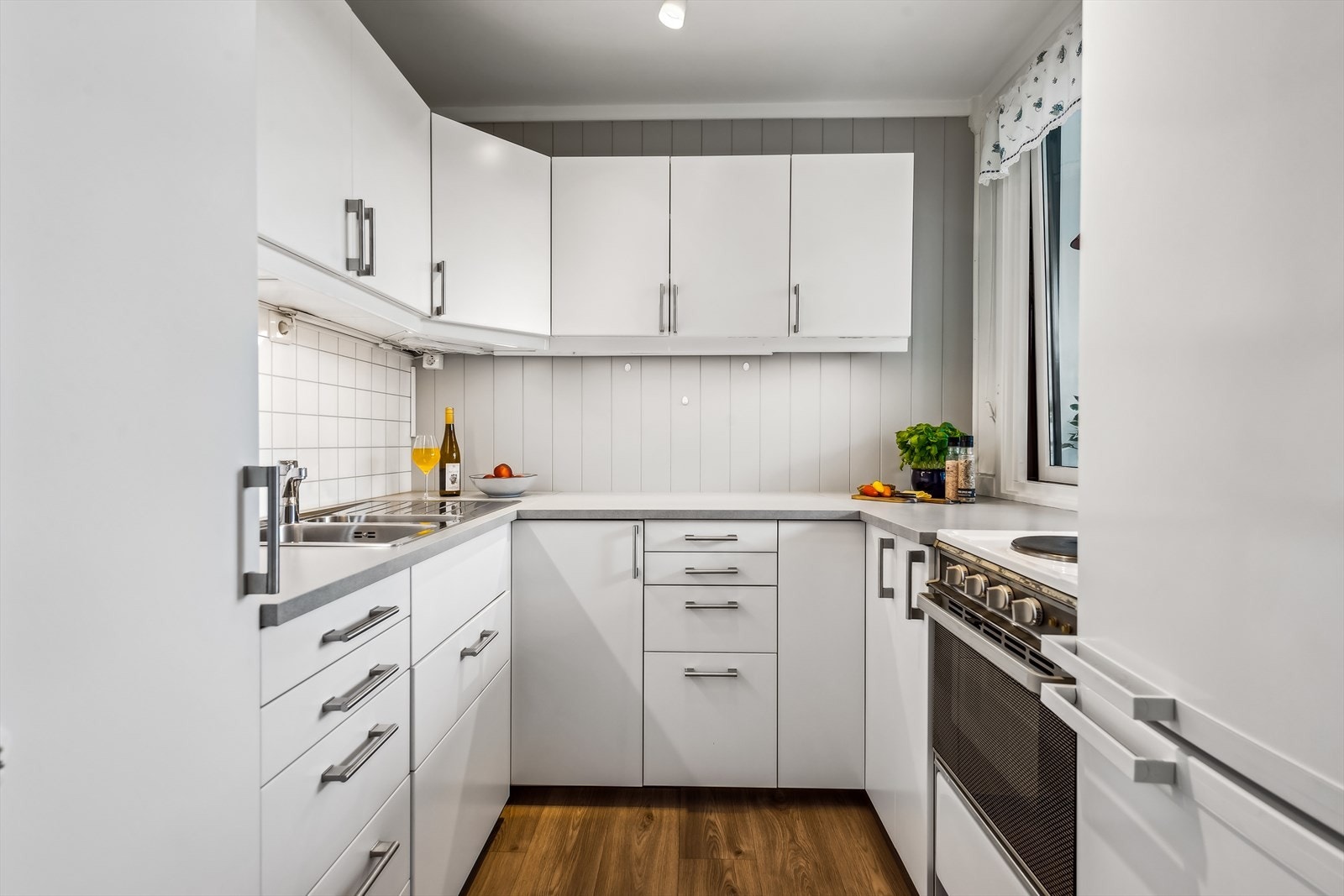 Kjøkkenet er delvis åpent mot stuen og er av god standard med lyse, glatte fronter. Galleribilde