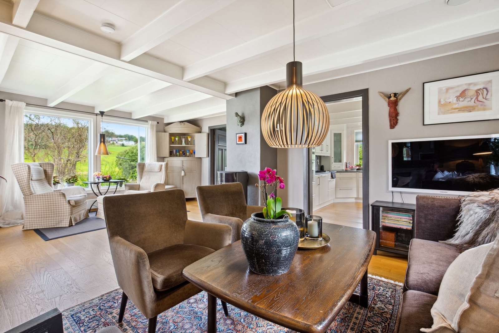 Romslig stue med plass til flere sittegrupper Galleribilde