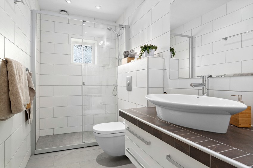 Bad med flislagt gulv med gulvvarme og flislagte vegger. Galleribilde