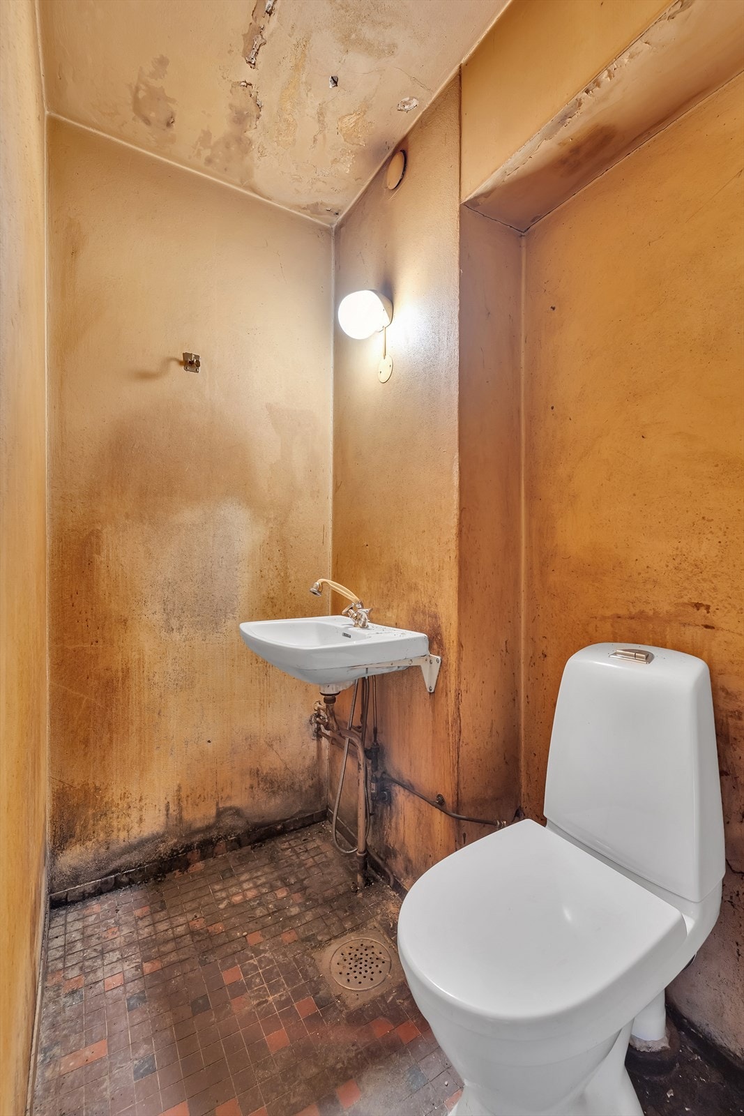 Bad med mosaikkfliser på gulv og tapetserte vegger. Dusjplass, servant og wc. Galleribilde