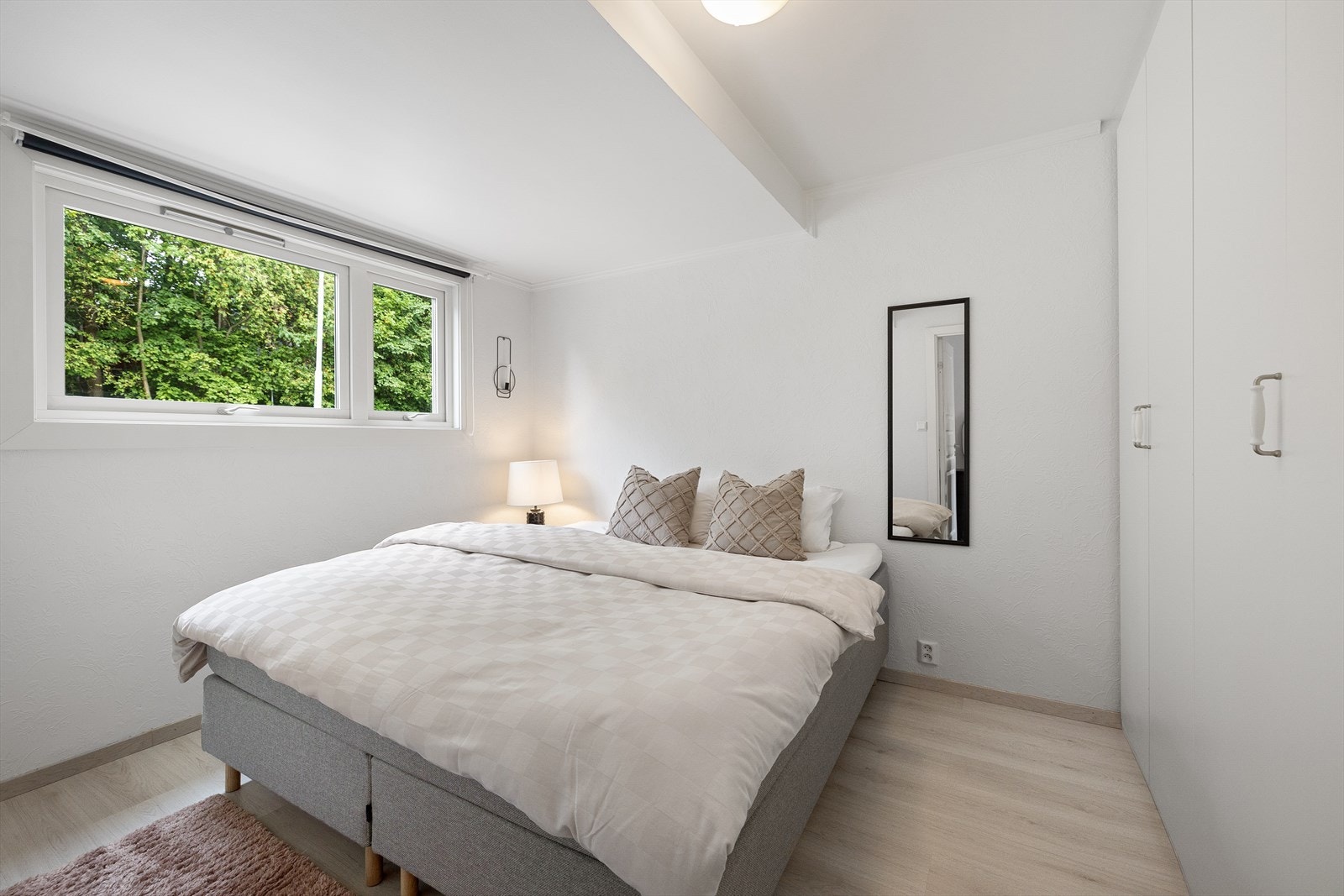 Lyst og tiltalende soverom med stort garderobeskap. Galleribilde