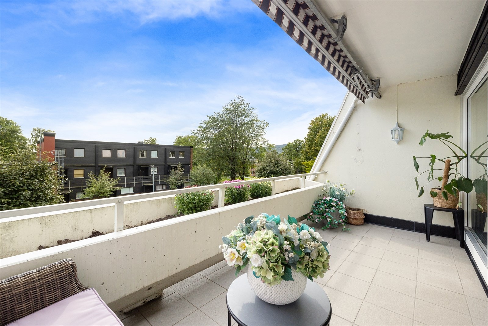 Fra stuen/spisestuen er det utgang til en lun og sydvendt balkong på ca. 9 kvm, med markise og pent opparbeidet blomsterbed. Galleribilde