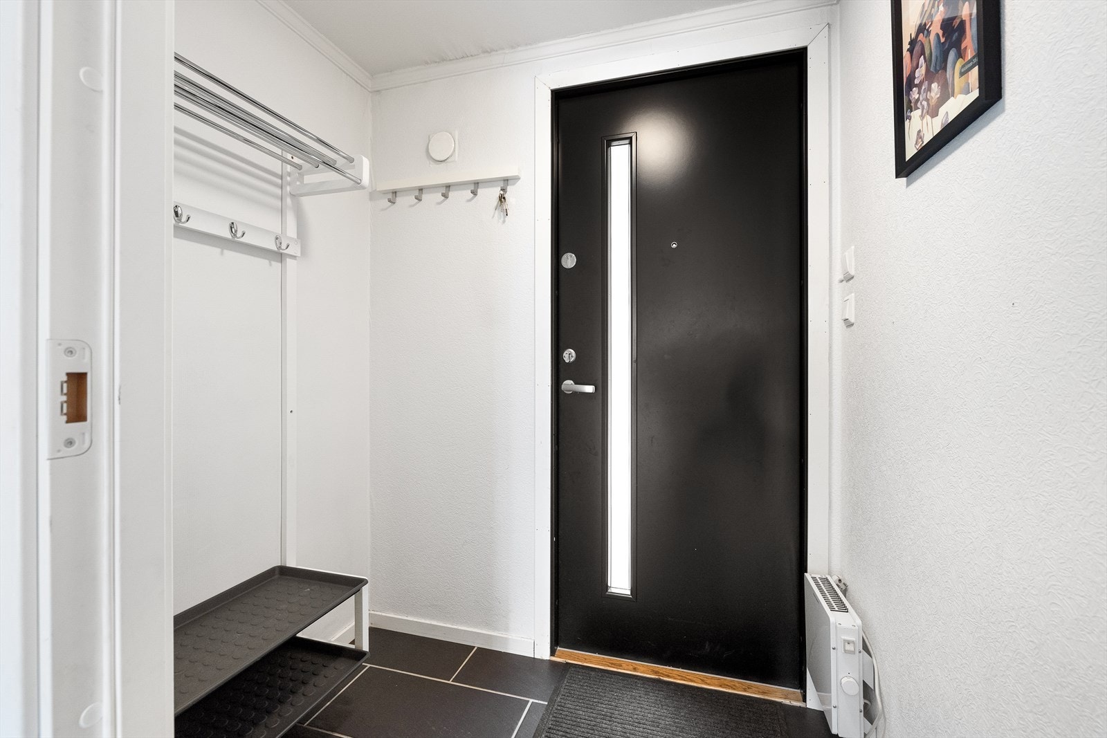 Lys og innbydende entré med fliselagt gulv, som gir et godt førsteinntrykk av leiligheten. Galleribilde