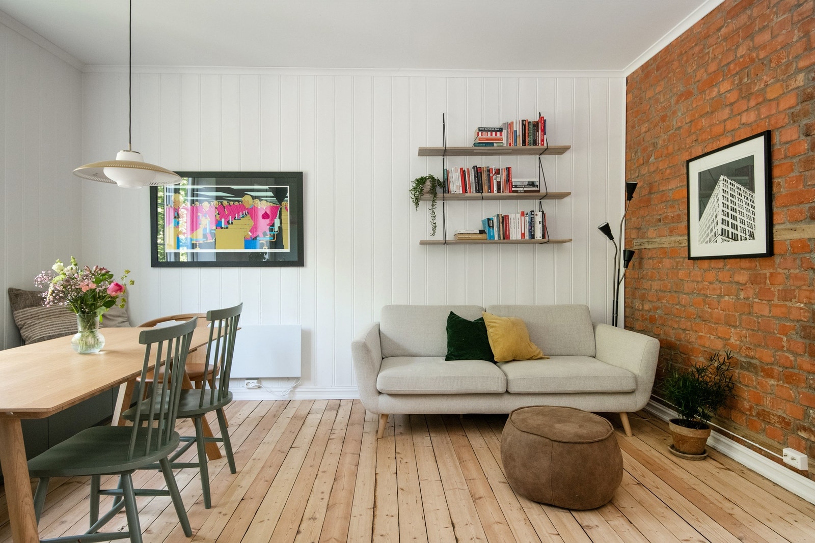 Originale detaljer er gjennomgående i leiligheten, i stuen er det originale tregulv, panel på vegger og eksponert murvegg. Galleribilde