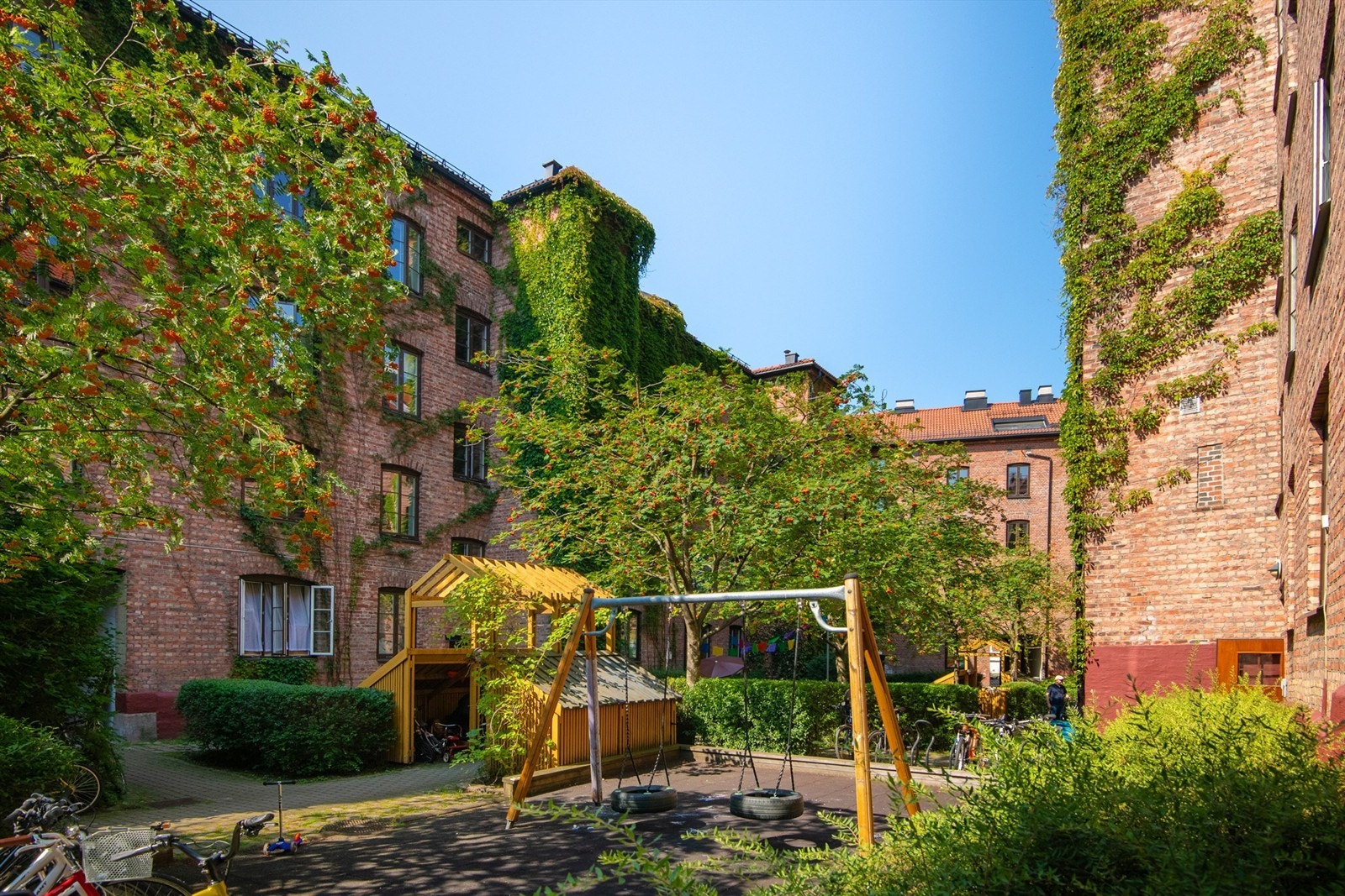 Opparbeidet fellesarealer med grøntarealer, beplantinger, lekestativ og grill. Galleribilde