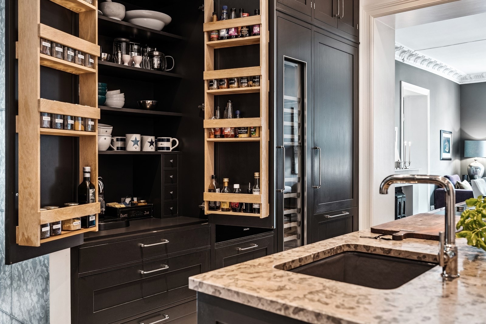 Mørk grå Kvänum kjøkkeninnredning fra 2018 med mattlakkede glatte fronter, underlimt kjøkkenvask i stein benkeplateinduksjonstopp og avtrekksvifte med kullfilter. Galleribilde