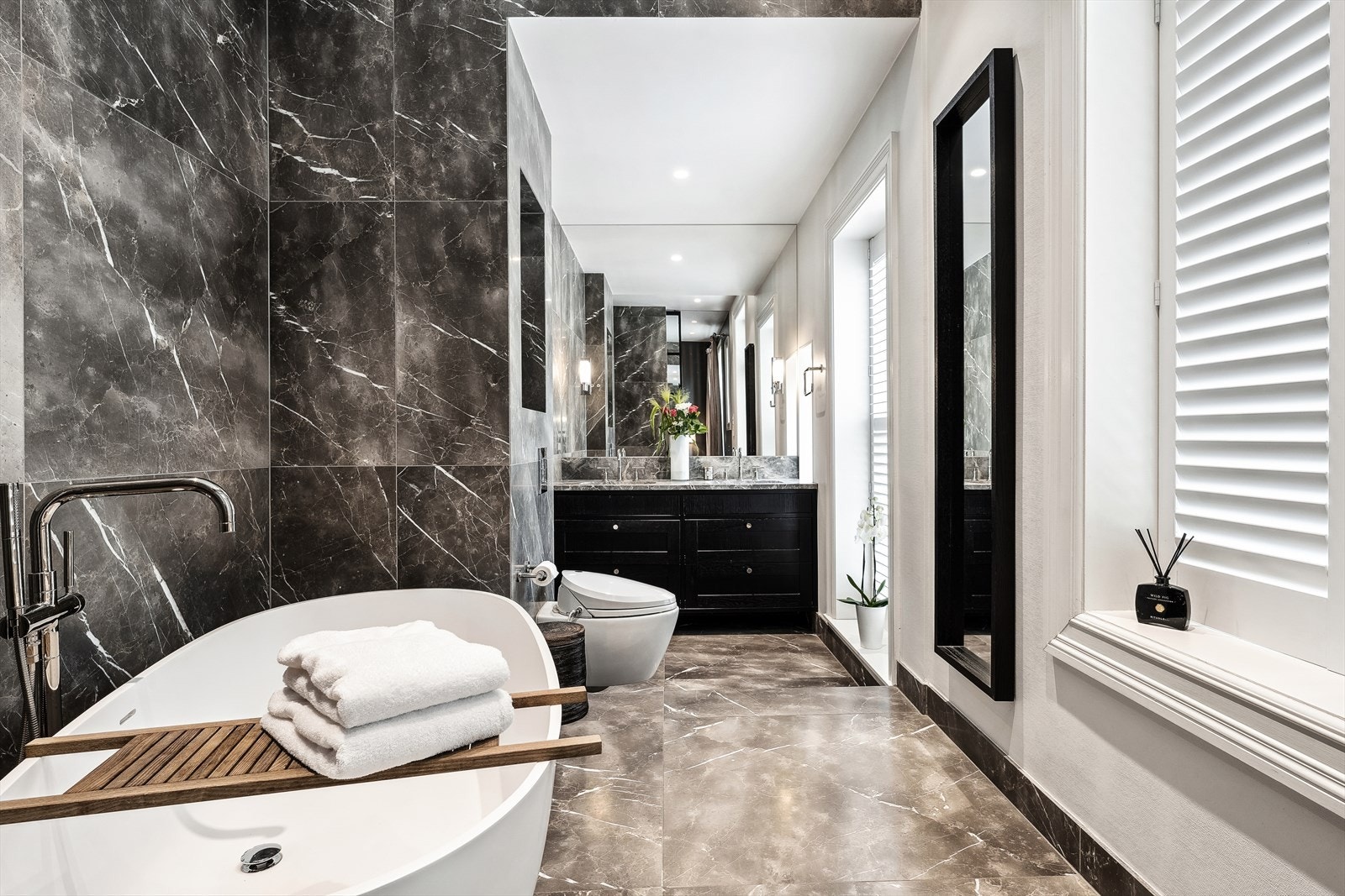 Badet er utstyrt med 2 servanter underlimt i stein benkeplate med servantskap, veggfestet toalett med skjult sisterne, design badekar med gulvmontert armatur, dusj med innebygget armatur, fossefall dusjhode, armaturer til badekar og dusj. Galleribilde