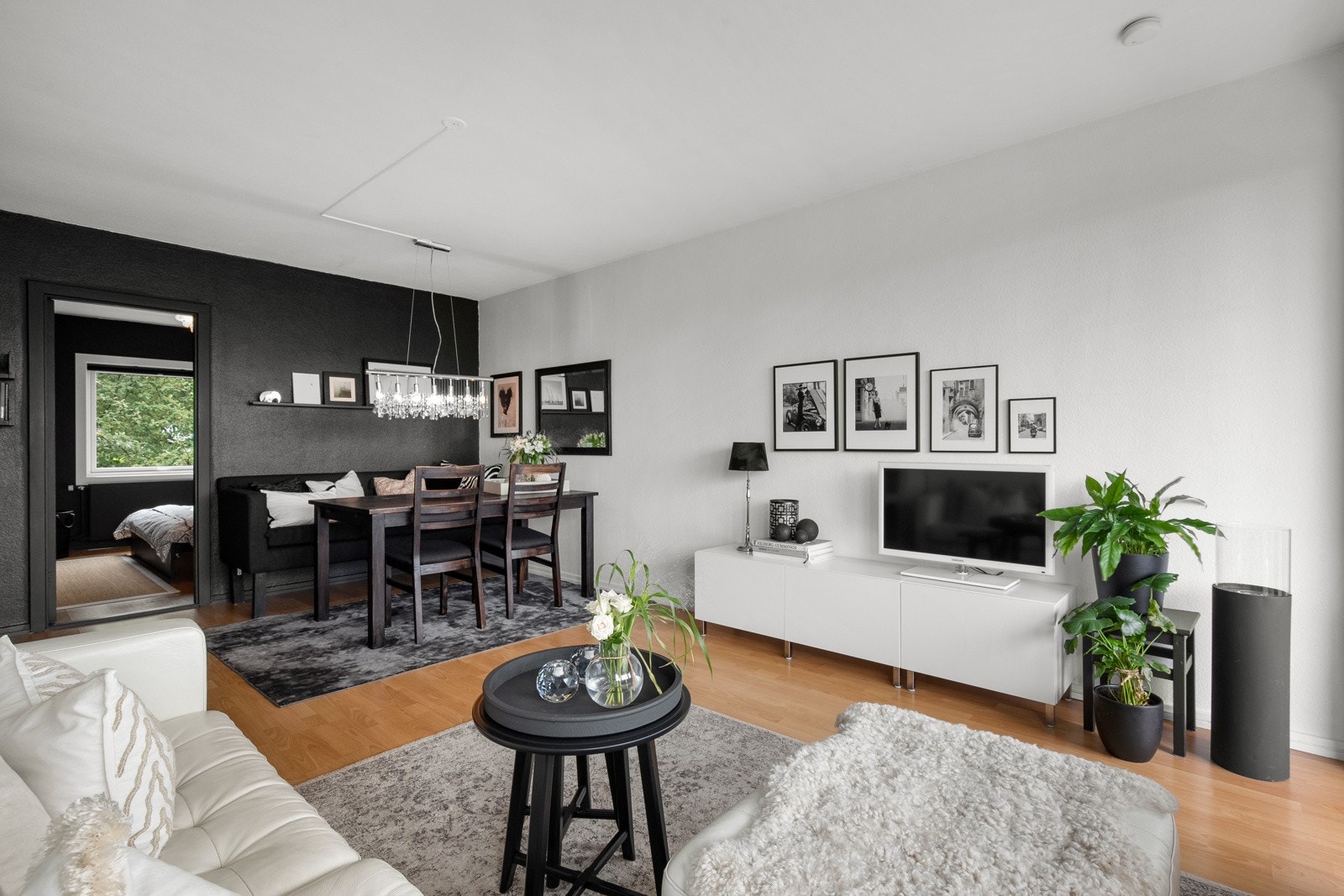 Stuen er malt i en lys farge, med en stilig kontrastvegg i en mørk fargenyanse som gir rommet et moderne og sofistikert preg. Galleribilde