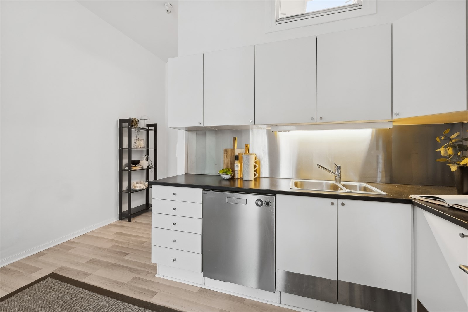 Benkeplaten er av laminat, og kjøkkenventilator med kullfilter. Det er godt med både skap- og benkeplass. Galleribilde