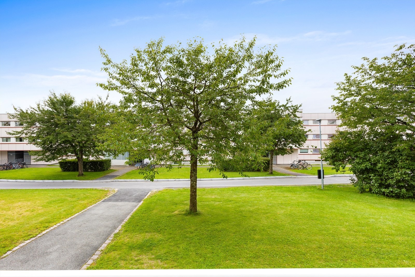 Pent opparbeidet fellesareal med gressplener, sittegrupper, lekeplasser m.m. Galleribilde