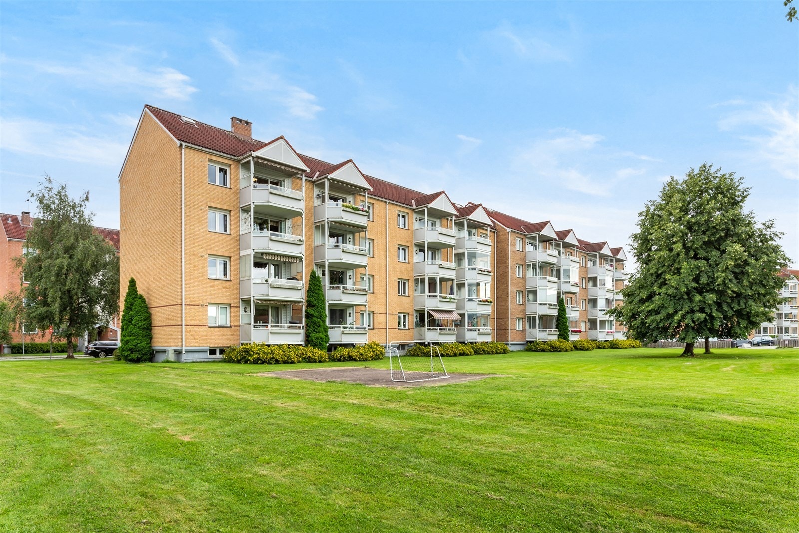 Fellesarealet er pent opparbeidet med plen, trær, diverse beplantning, lekeplass, sittegrupper og asfalterte internveier. Galleribilde