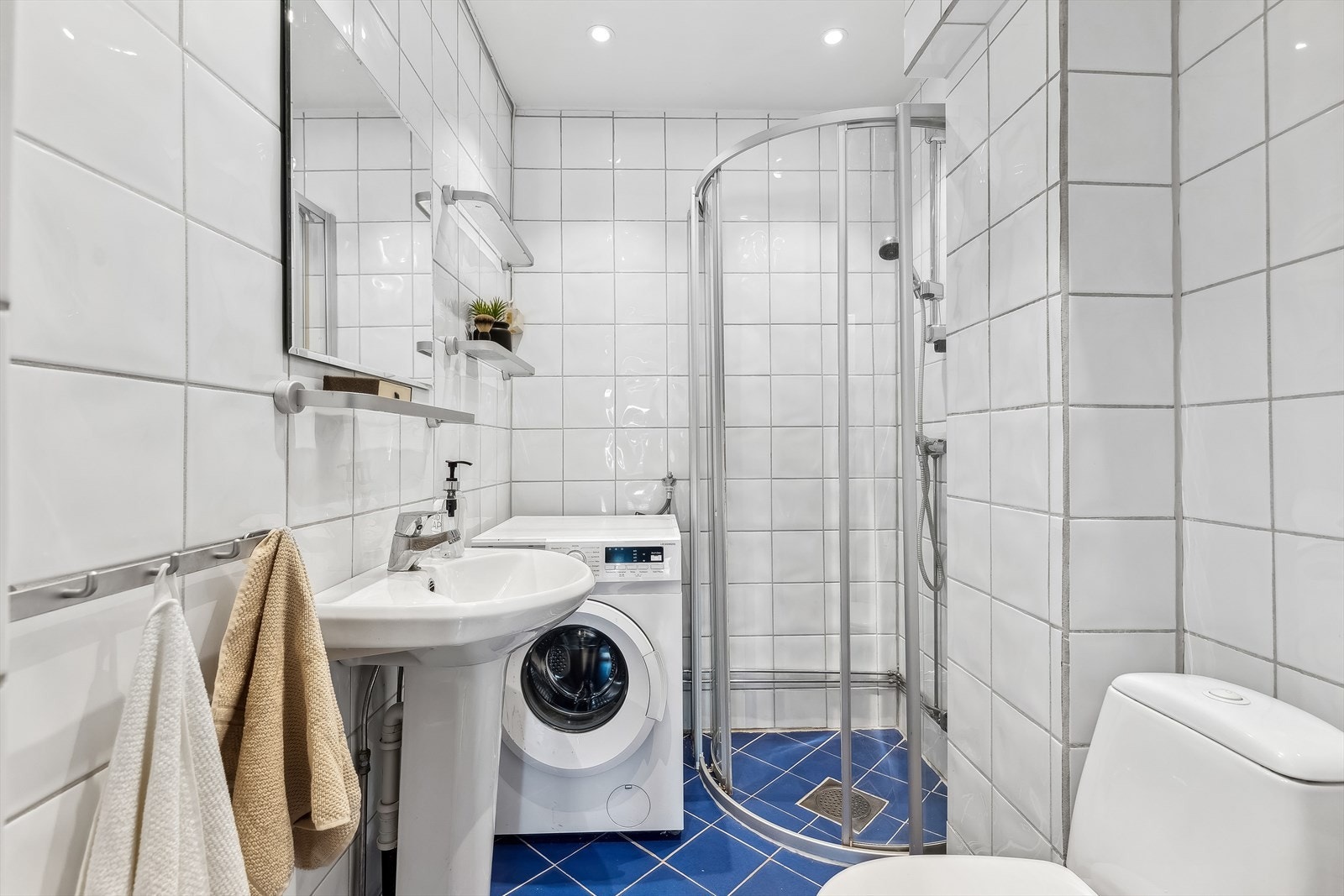 Flislagt bad med opplegg for vaskemaskin, varmekabler og downlights. Galleribilde