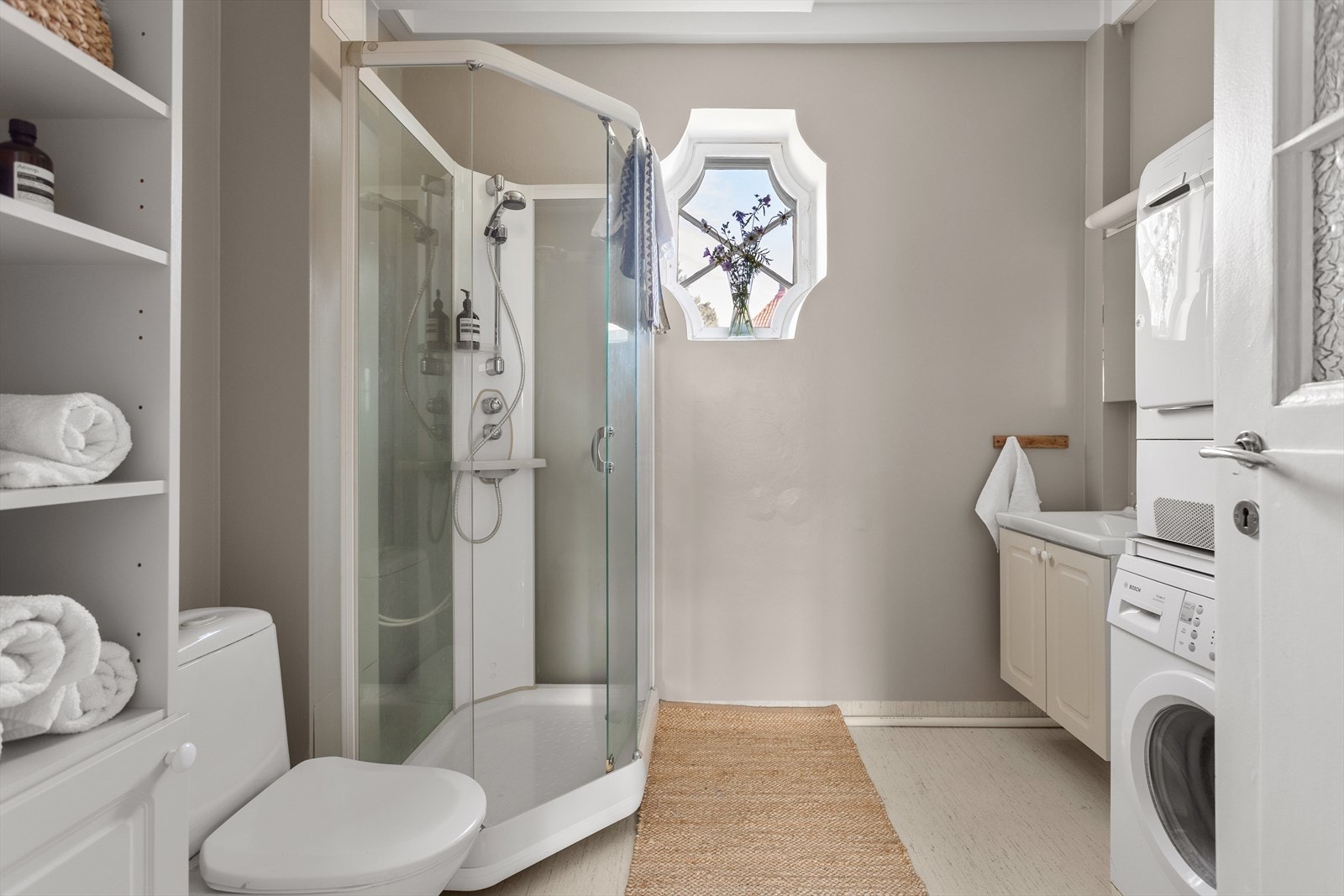Badet er utstyrt med wc, dusjkabinett, servantskap og opplegg for vaskemaskin og tørketrommel. Galleribilde