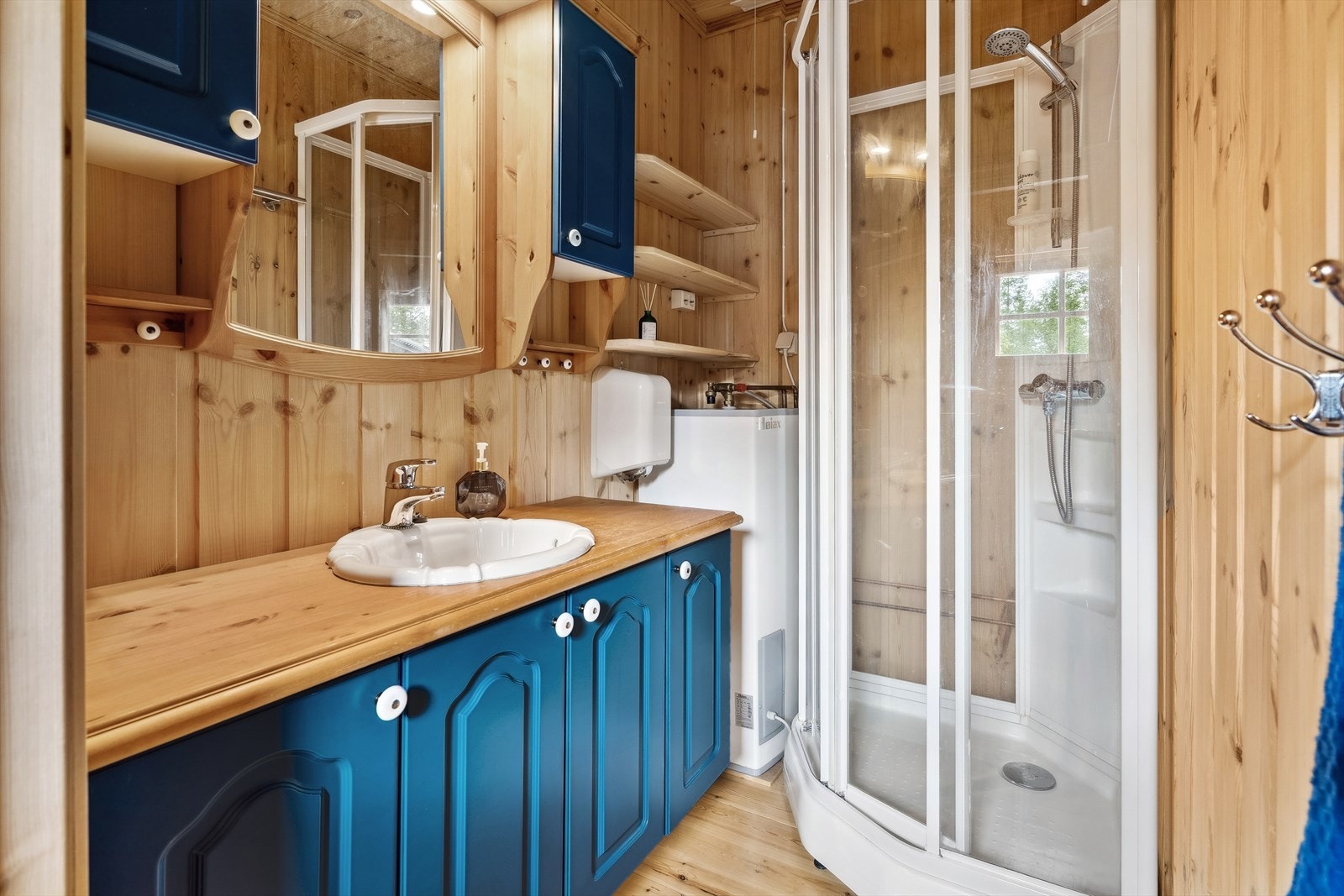 Et enkelt bad med det du trenger av skapplass og dusj Galleribilde