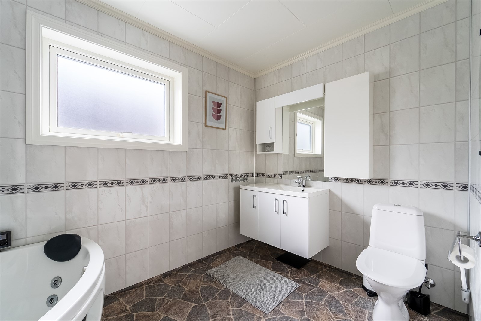 Bad hovedetasjen med massasjebadekar, wc og seksjon m/servant. Galleribilde