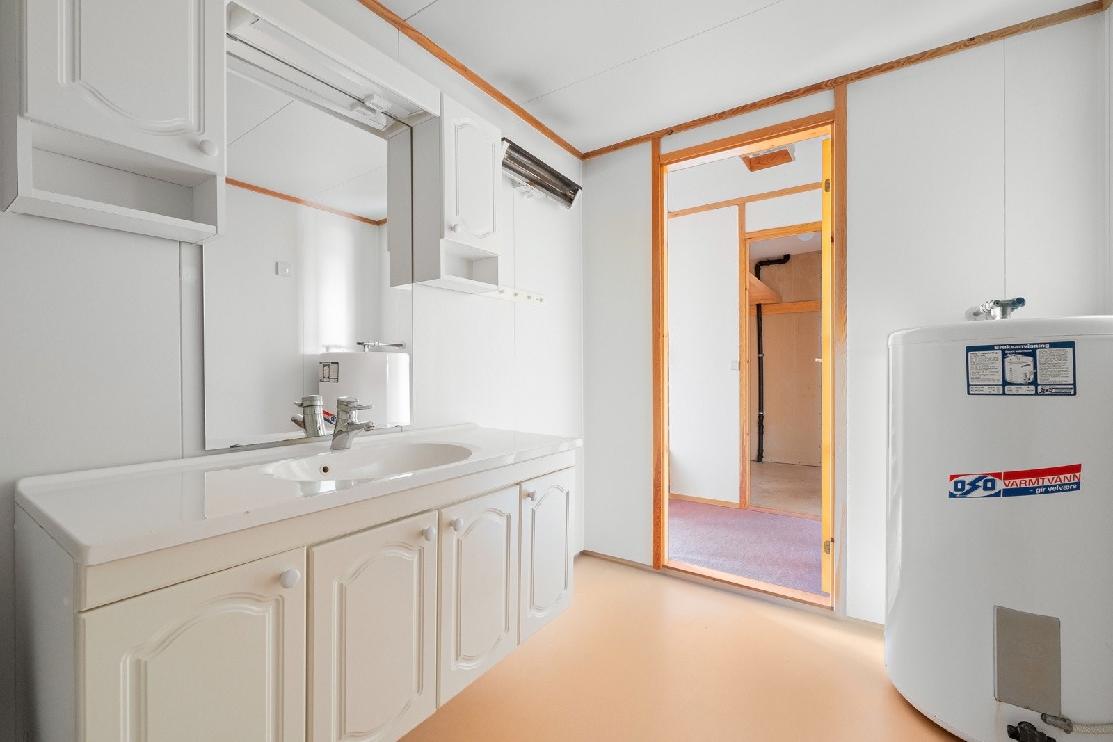 Eldre baderom (fra 1989) i boligens underetasje m/behov for oppgradering. Badet har vinylbelegg på gulv og malte baderomsplater på veggflater. Innredningen består av profilert baderomsmøblement, speil, toalett, utslagsvask, samt badekar m/dusjløsning. Galleribilde