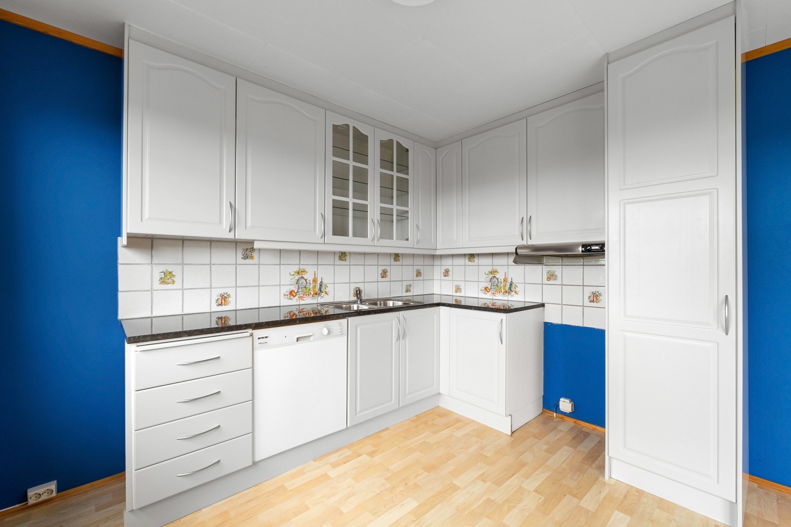 Det er avsatt plass til frittstående komfyr og kjøleskap i egen nisje, samt opplegg og plass for oppvaskmaskin. Elektrisk ventilator over kokesonen. Galleribilde