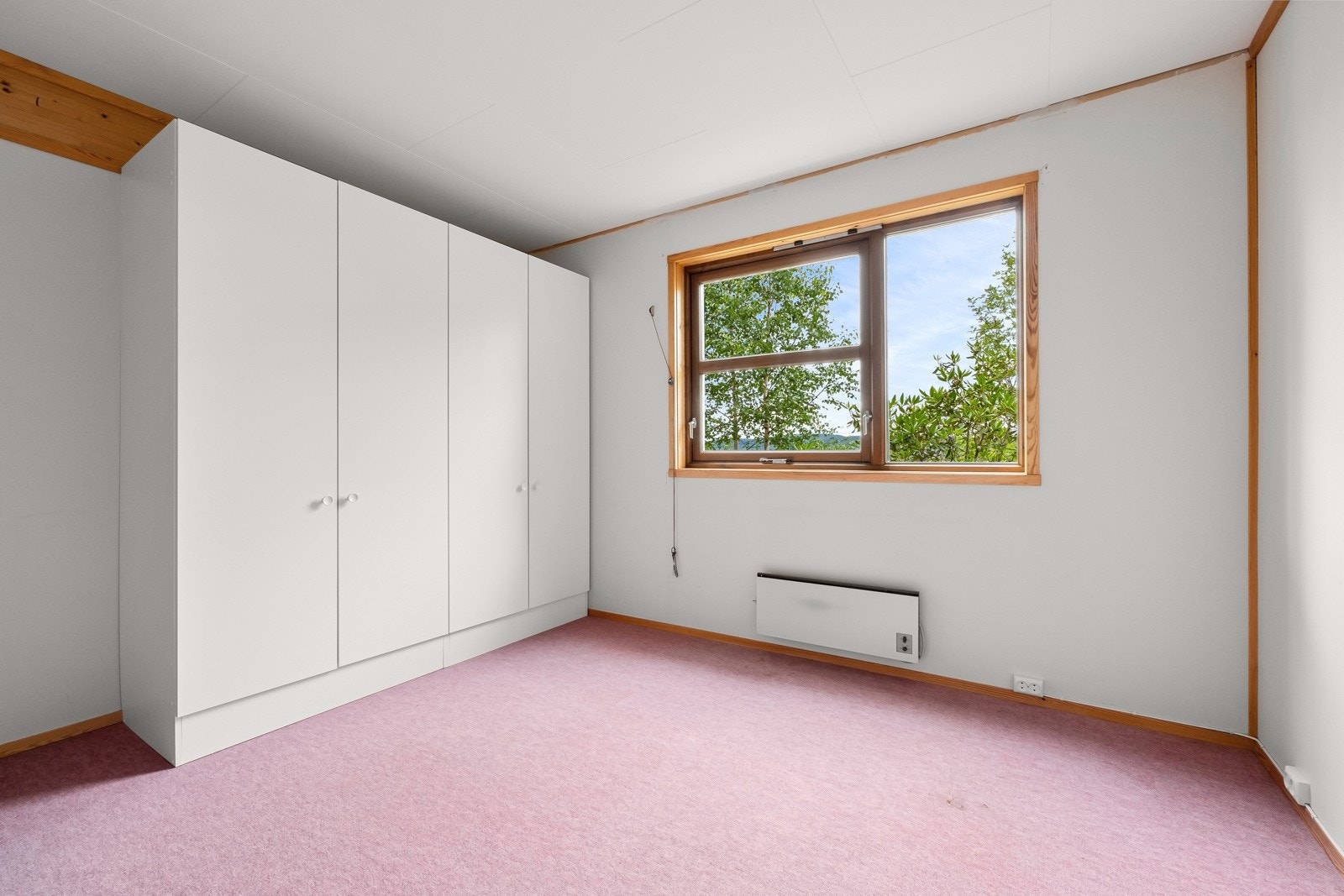 Soverom 2 har lysmalte veggflater, teppebelagt gulv og garderobeskap. Galleribilde