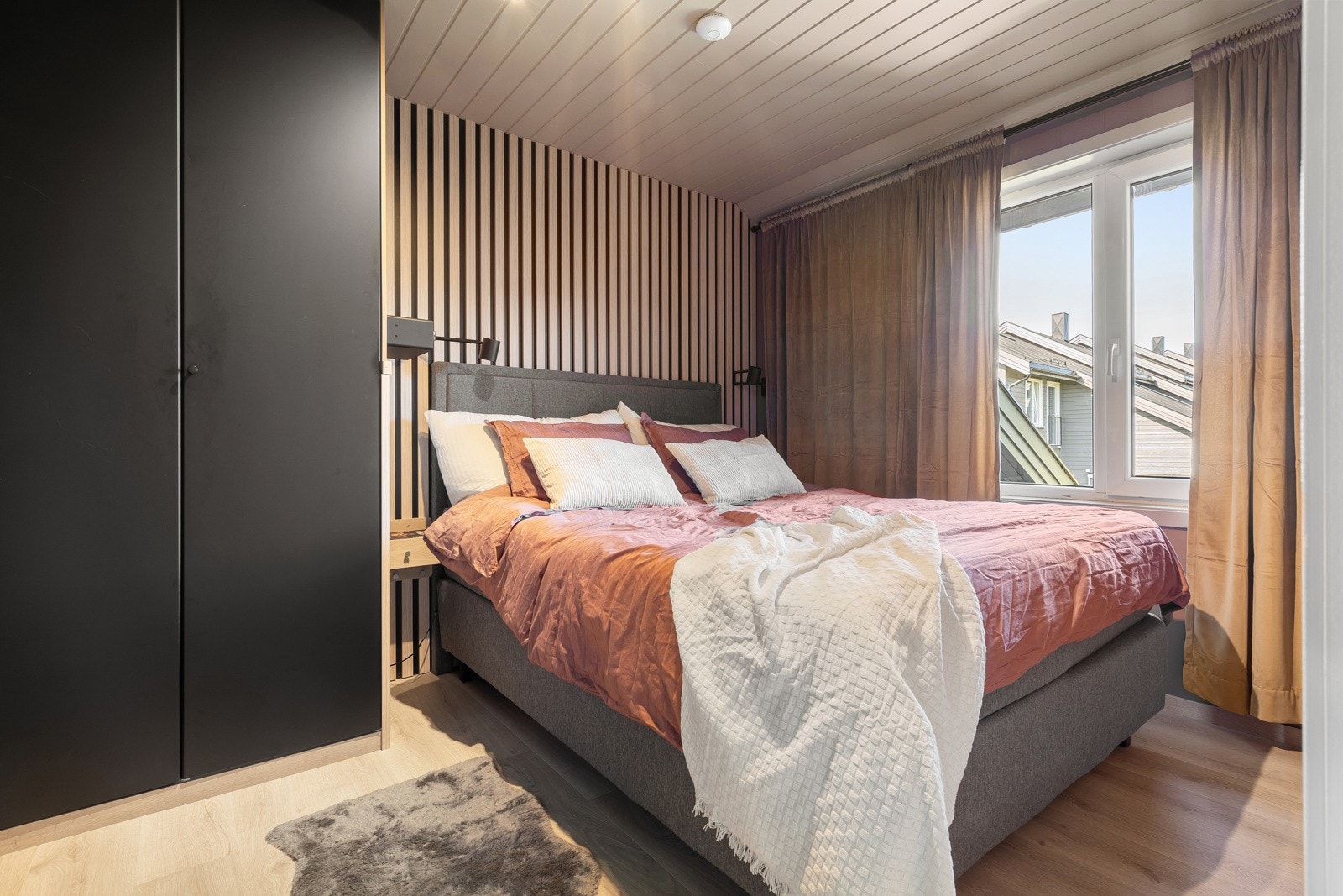 Lekkert hovedsoverom med plassbygget garderobe og spiler på vegg. Galleribilde