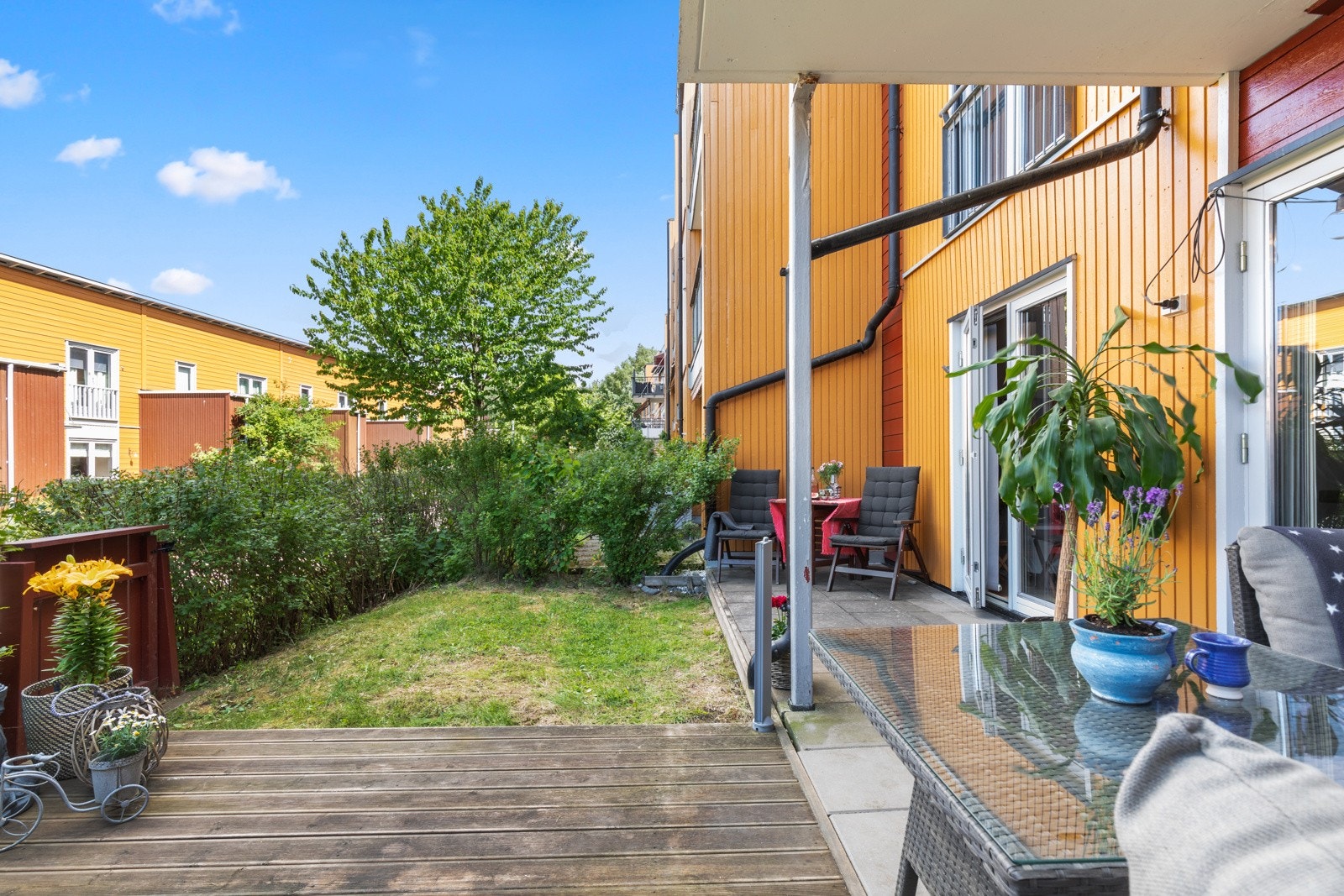 Terrassen har dekke av betongheller og ble tilbygd med platting i 2019. Mot nabo er det oppført levegg. Galleribilde
