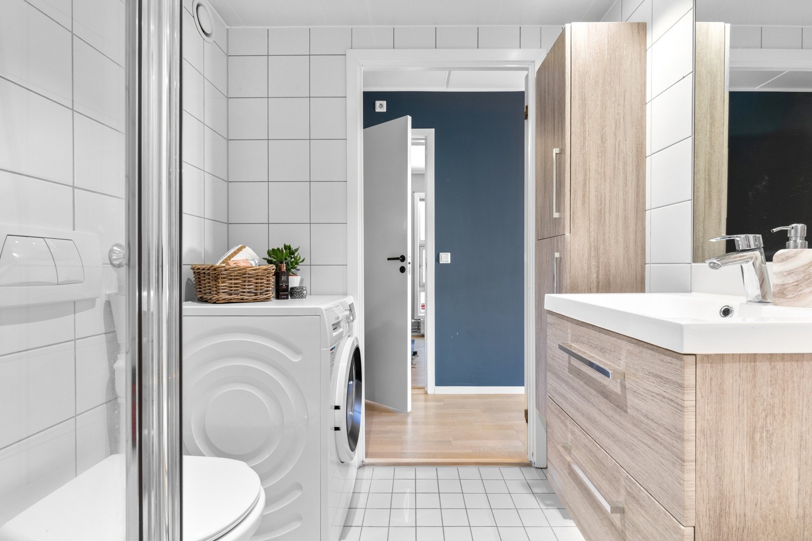 Leiligheten har et romslig, flislagt bad med varme i gulvet og downlights i himling. Innredningen har trefolierte fronter og består av et skuffemøblement med heldekkende servant. Galleribilde