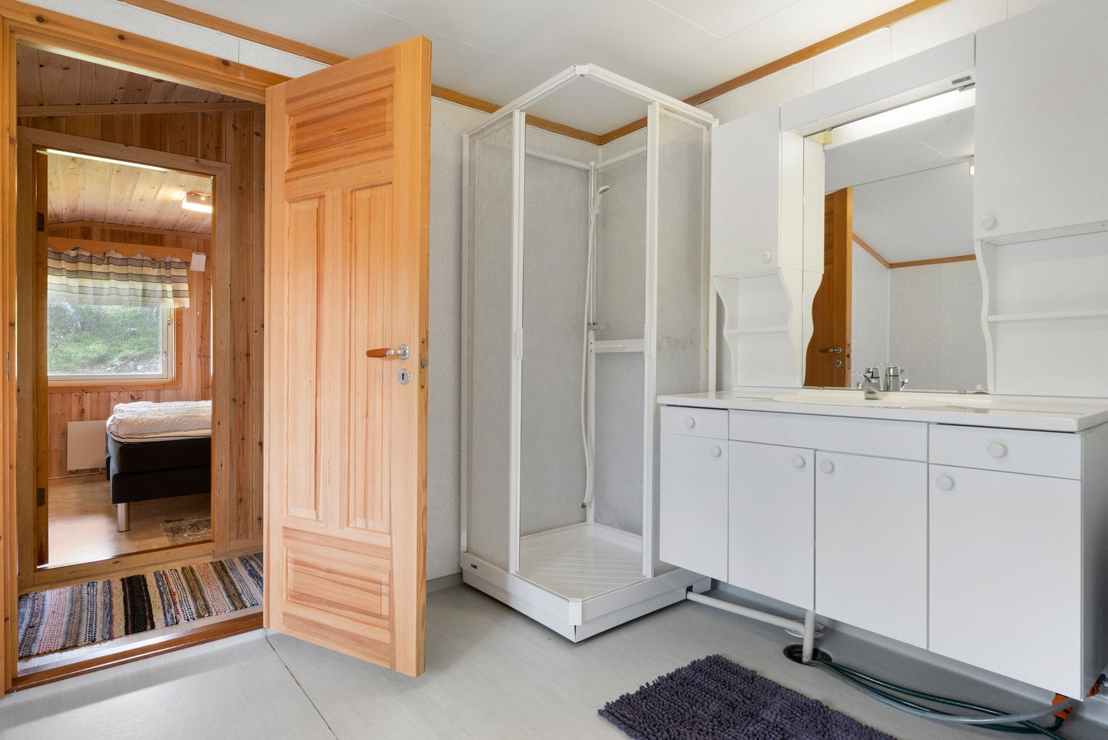 Badet inneholder innredning med servant, toalett, dusjkabinett og varmtvannstank. Galleribilde