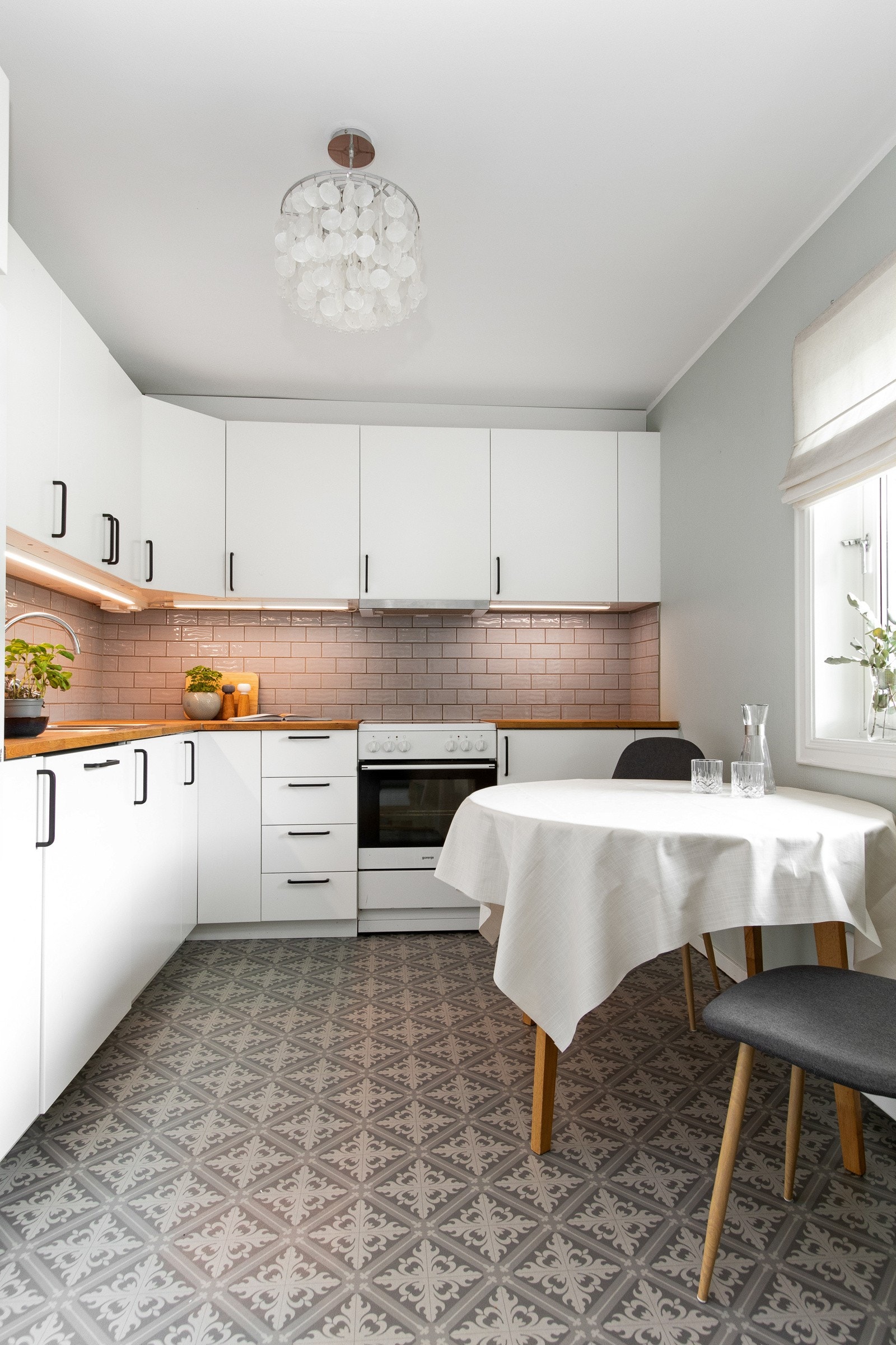 Innredningen ligger langs to sider av rommet med hvite, glatte fronter, benkeplate av heltre og nedfelt oppvaskkum. Galleribilde