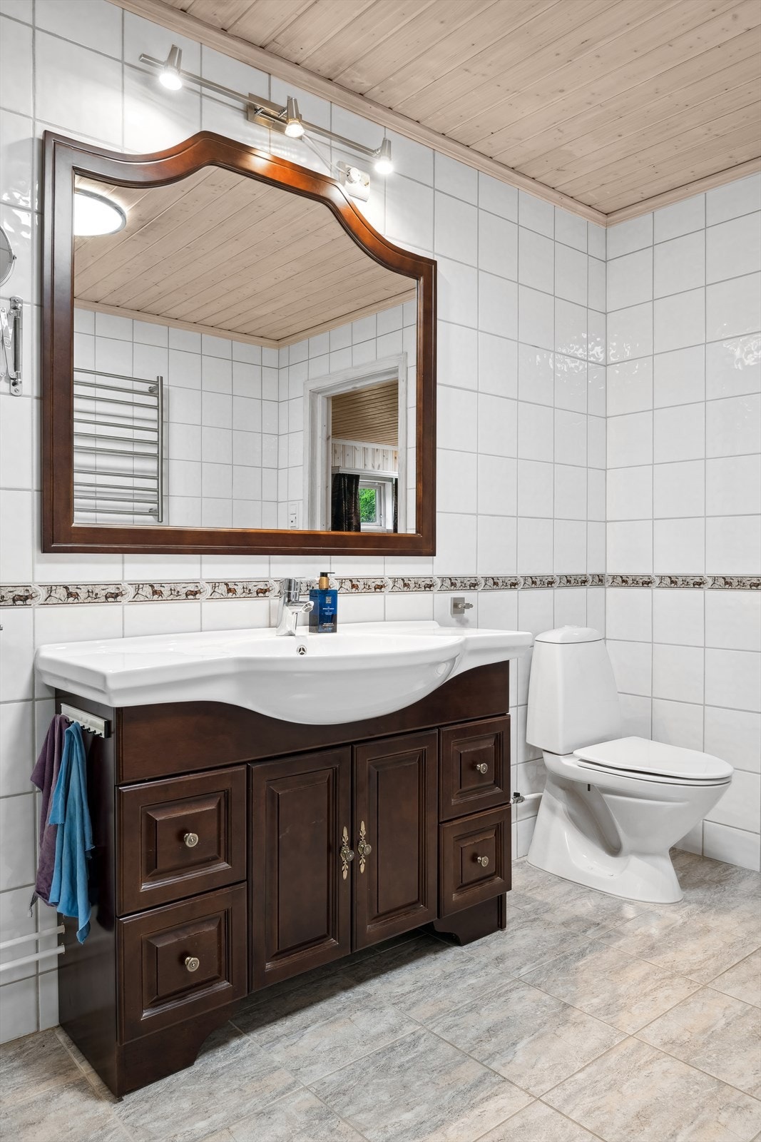 Innredning med servant med underskap. Speil med tilhørende belysning. Videre har badet dusjkabinett og gulvmontert toalett. Opplegg til vaskemaskin. Galleribilde