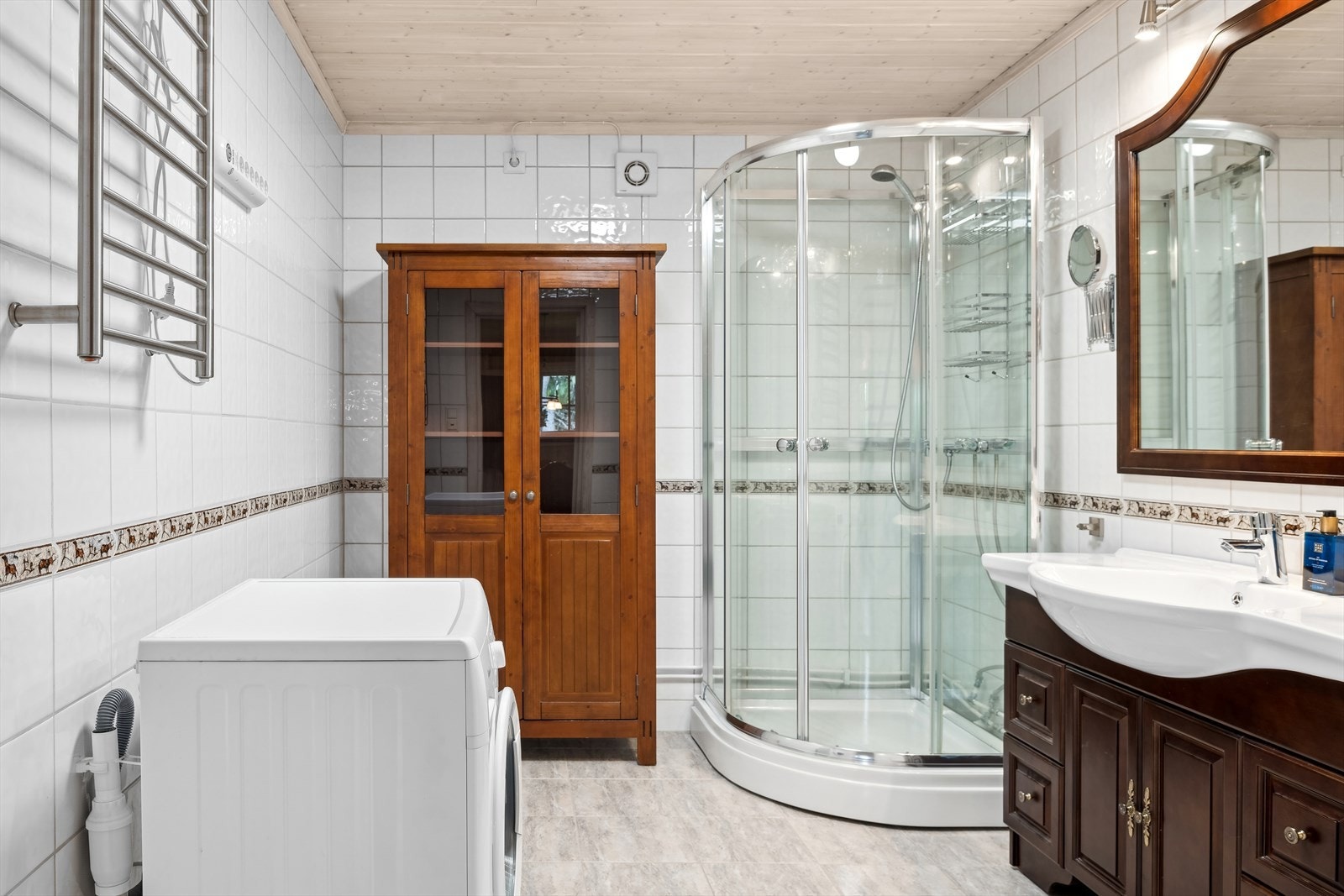 Baderommet har lyse fliser på gulv og vegg. Galleribilde