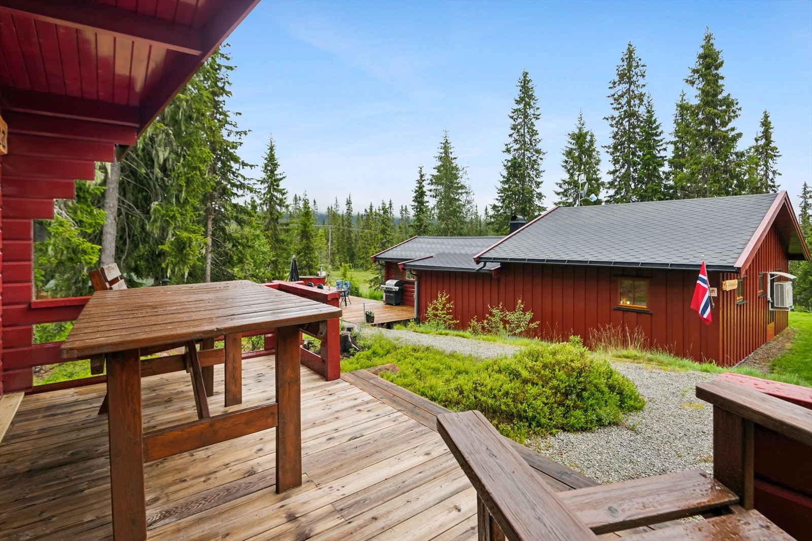 Koselig og lun uteplass utenfor annekset med delvis tak over platting. Galleribilde