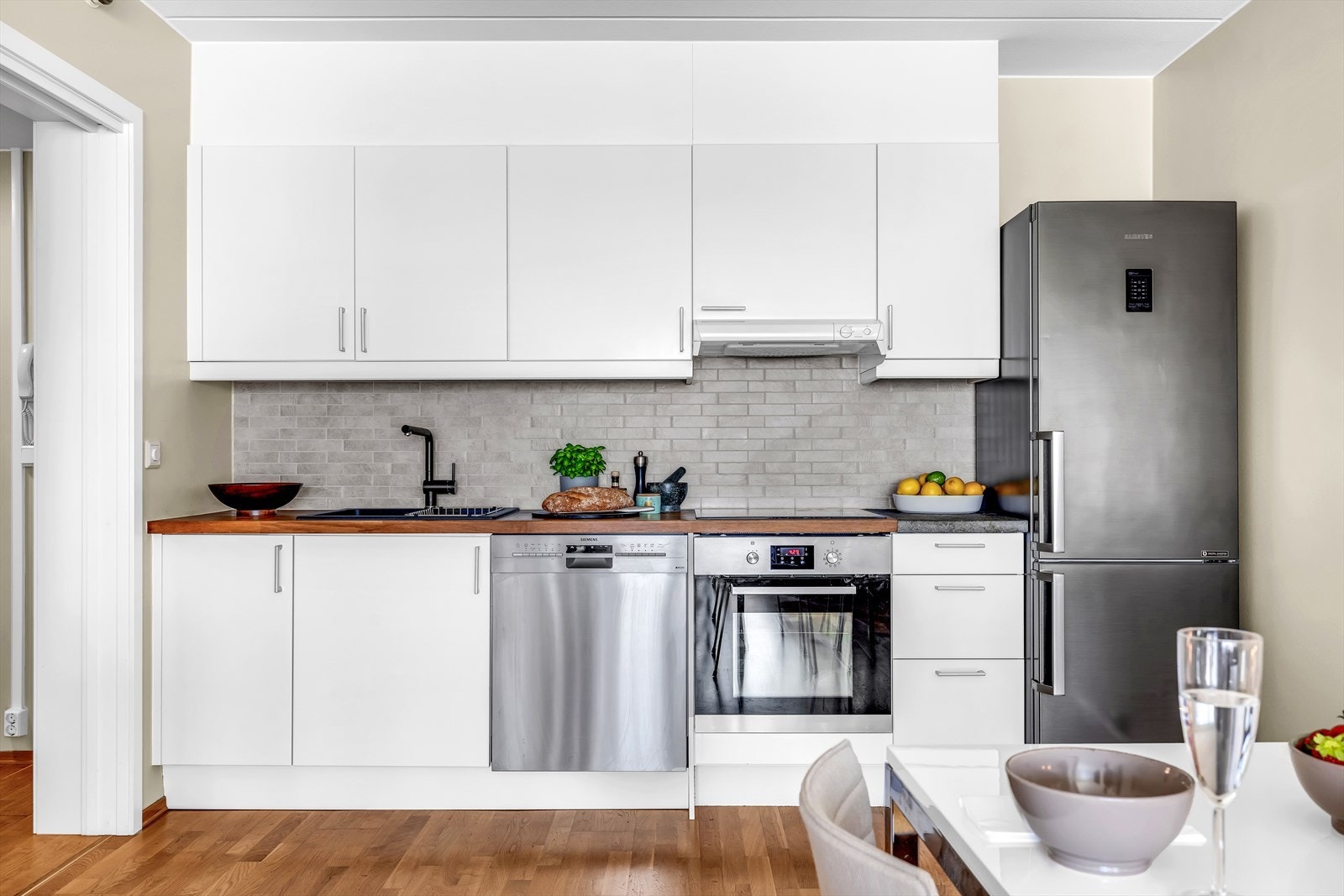 Moderne kjøkken med delvis integrerte hvitevarer. Benkeplate i tre Galleribilde