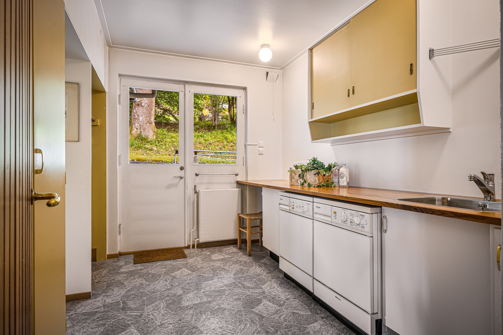 Vaskerom/grovkjøkken ligger vegg i vegg med kjøkkenet og har utgang til hagen Galleribilde