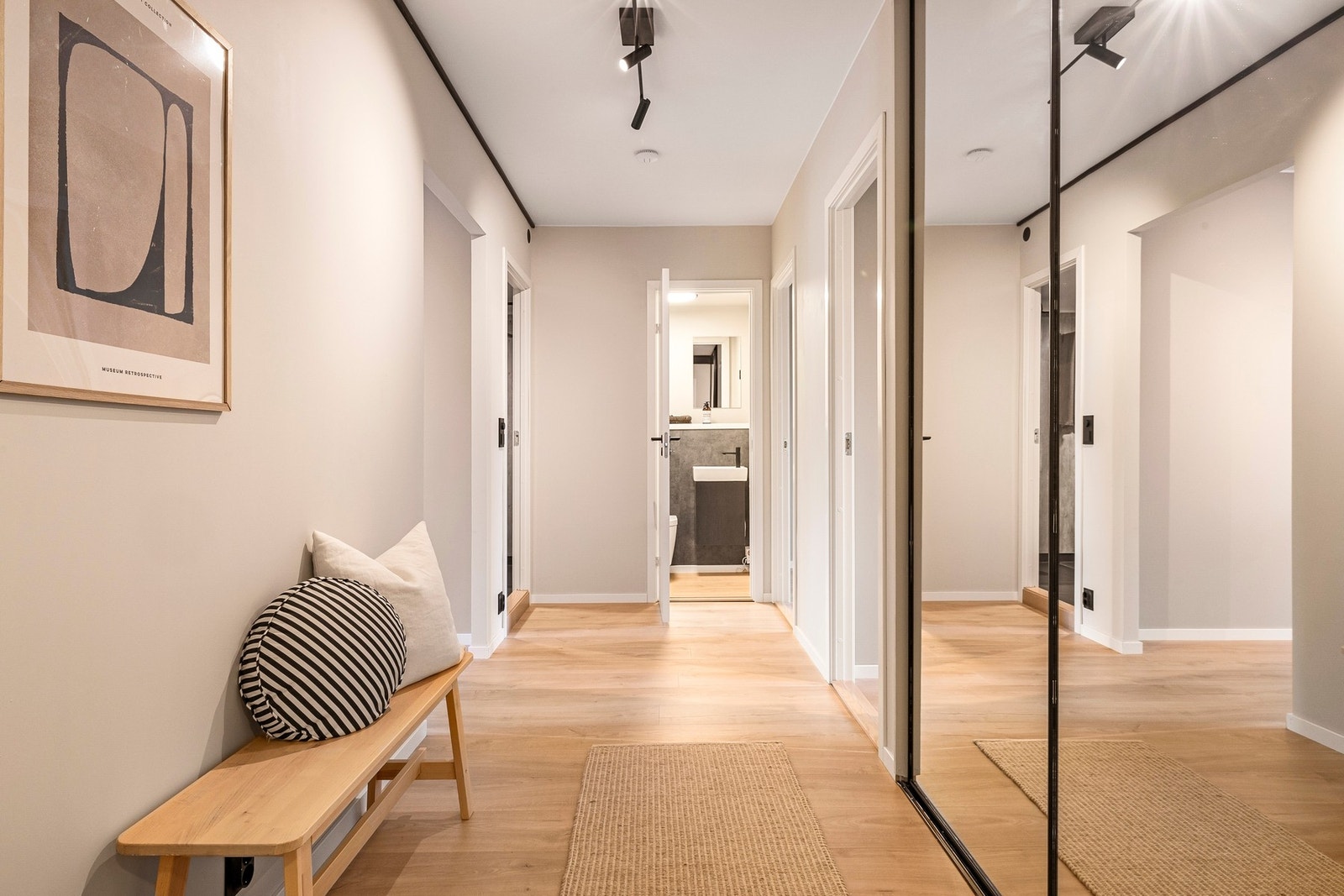 Entréen er lys og luftig med stor praktisk skyvedørsgarderobe Galleribilde