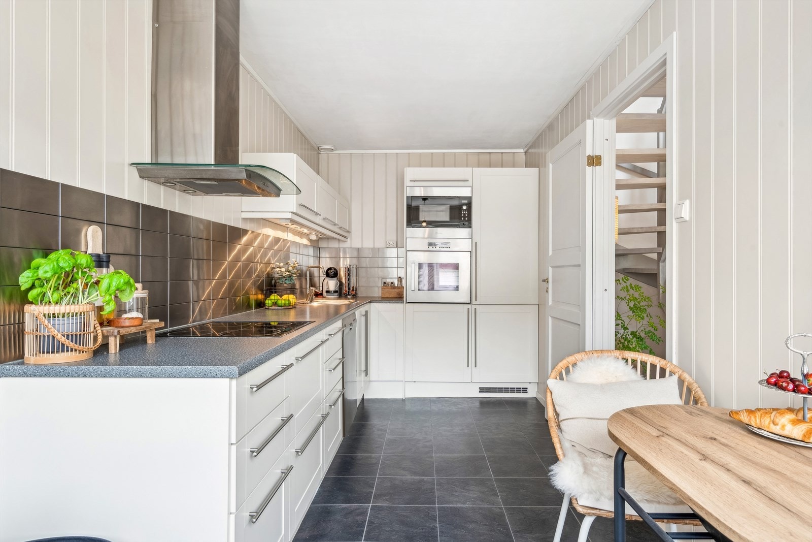 Kjøkkeninnredning fra 2007 med under-/overskap og høyskap. Profilerte fronter. Benkeplater av laminat med nedfelt kum i rustfritt stål og ett-greps blandebatteri. Galleribilde