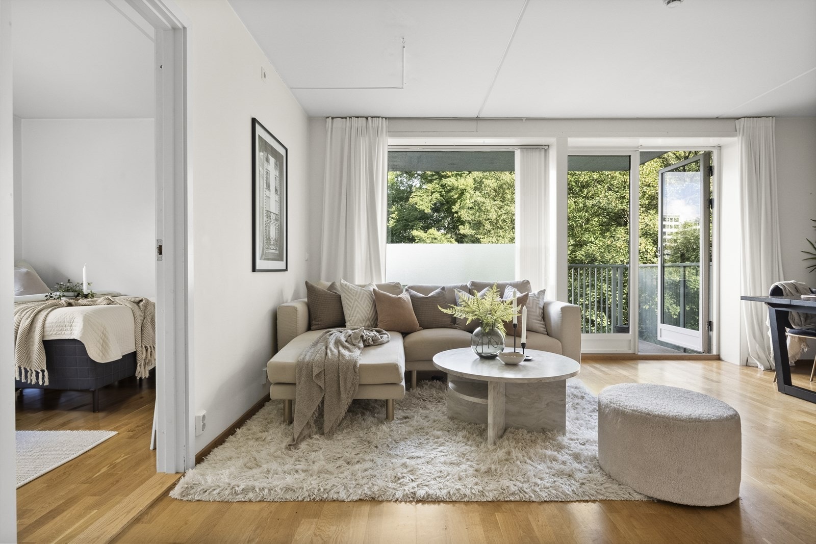 Store vindusflater og balkongdør gir godt innslipp av naturlig lys. Det er grønt og fint utenfor Galleribilde