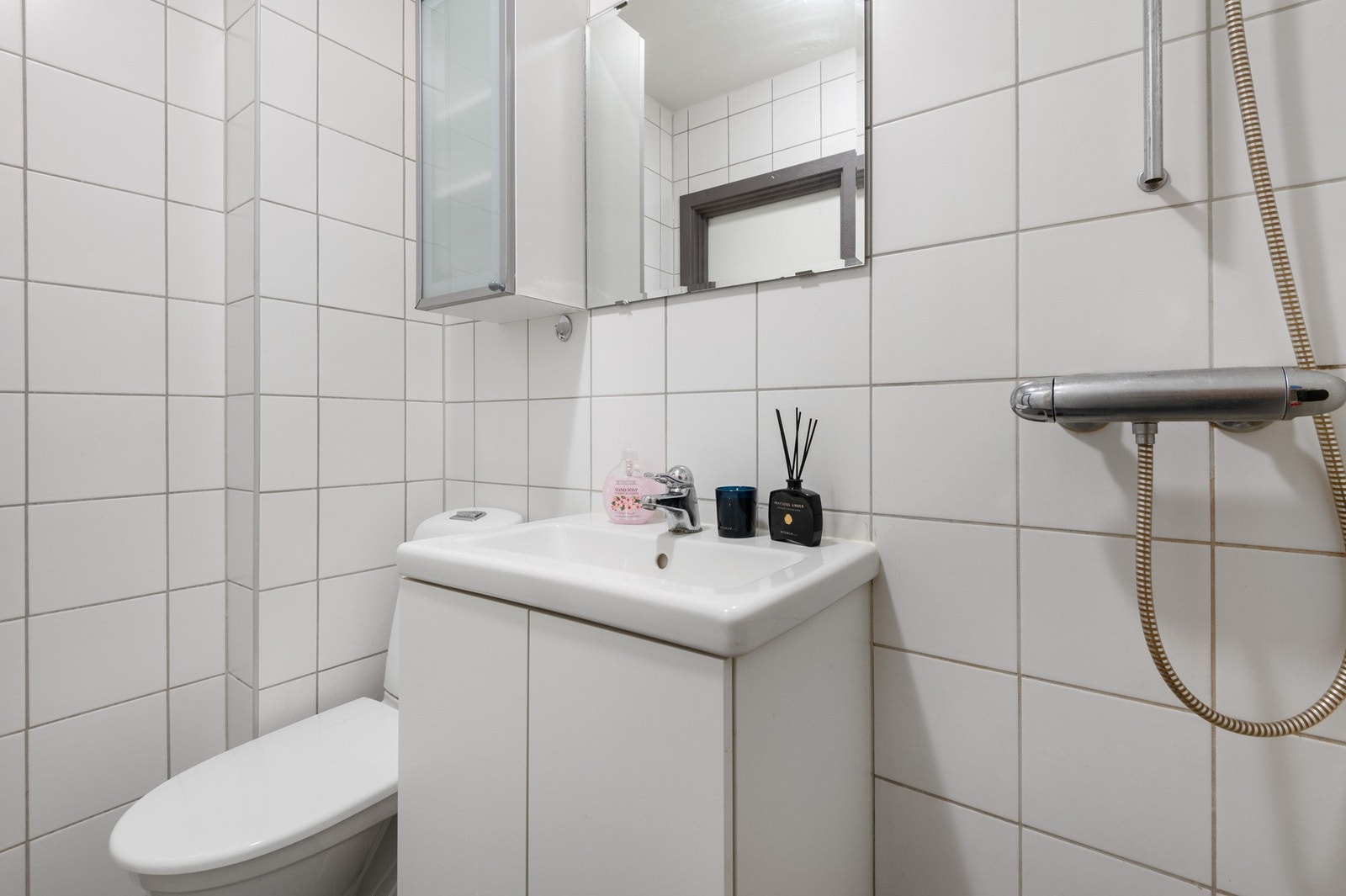 På badet har man toalett, servantskap og dusjhjørne med forheng Galleribilde
