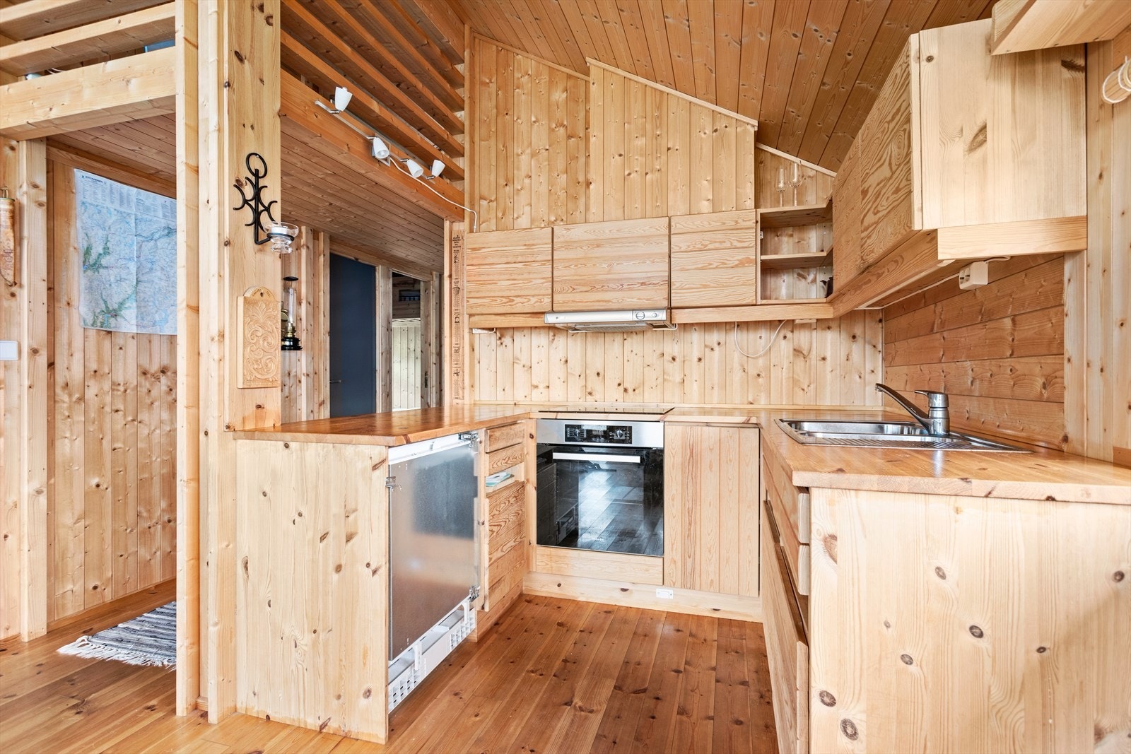 Kjøkkeninnreiing med Ålhytteinteriør med slette frontar og benkeplate i heiltre. Galleribilde