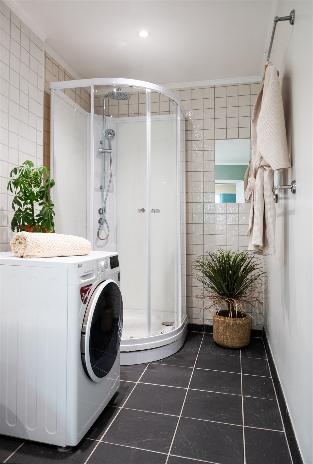 Badet har et flislagt gulv med elektriske varmekabler og plass til vaskemaskin. Galleribilde