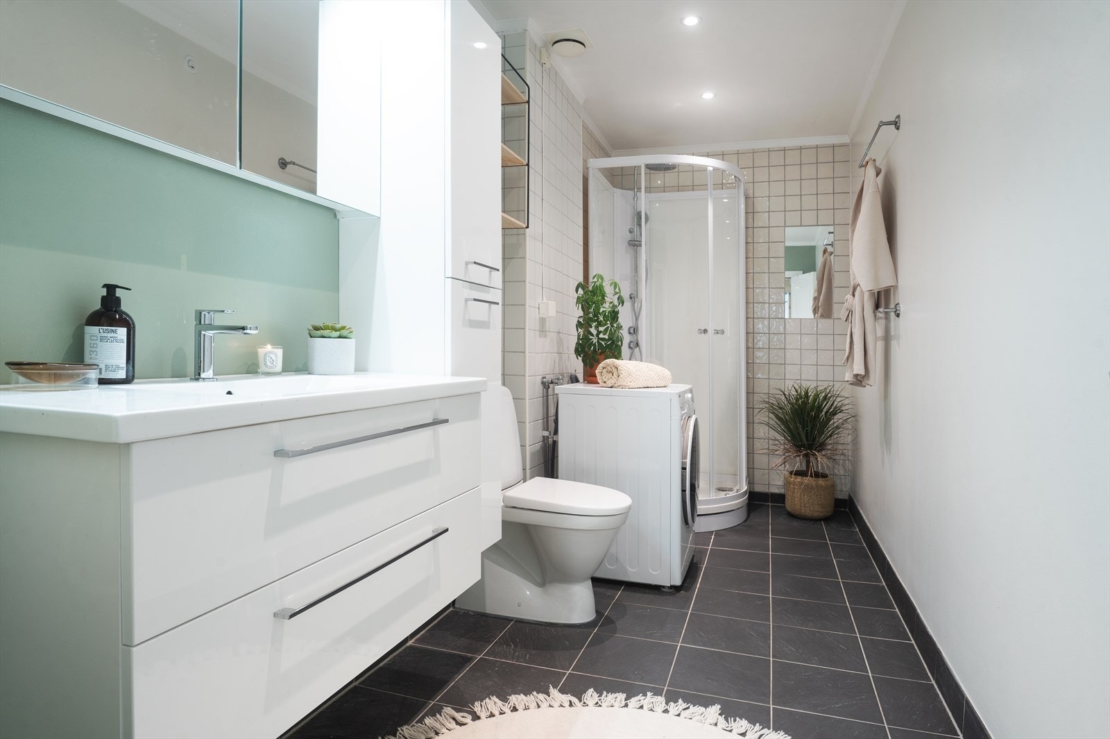 Pent bad med flislagte og malte overflater, samt malt glatt himling med innfelte downlights. Galleribilde