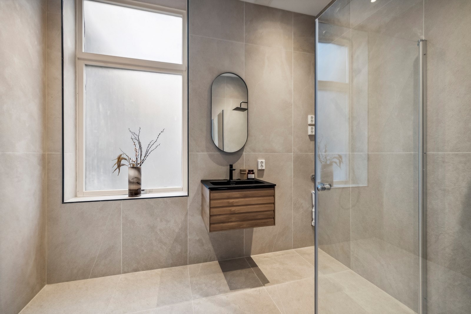 På badet er det dusjnisje, vegghengt toalett og baderomsinnredning.
Opplegg for vaskemaskin. Galleribilde